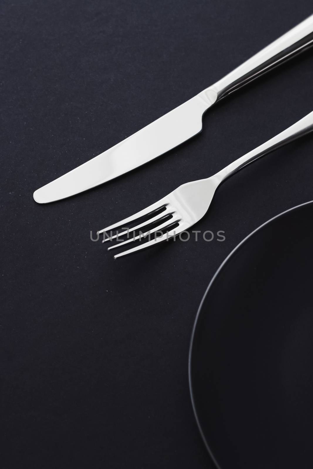 Empty plates and silverware on black background, premium tableware for holiday dinner, minimalistic design and diet by Anneleven