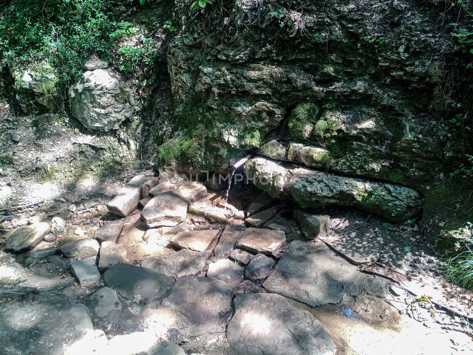 a tube inserted into the spring for the convenience of a set of drinking water. Shapsug Forest, Shapsugskaya Village.