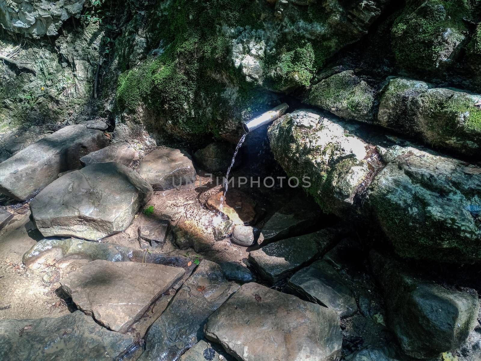 a tube inserted into the spring for the convenience of a set of drinking water. Shapsug Forest, Shapsugskaya Village.