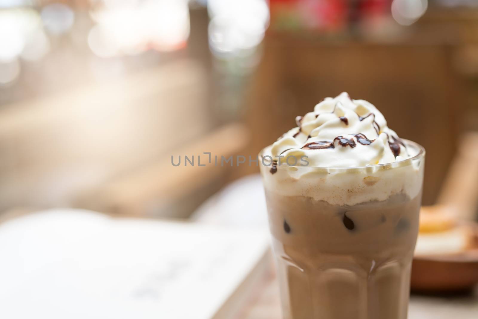 cup of iced mocha coffee on wooden table background. food and dr by psodaz