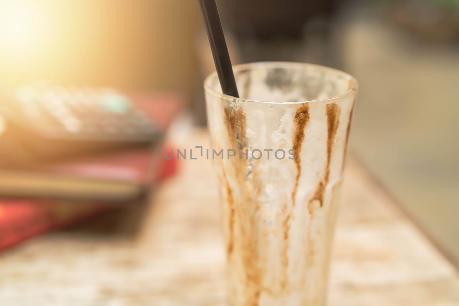 empty cup of iced mocha coffee on wooden table background. by psodaz