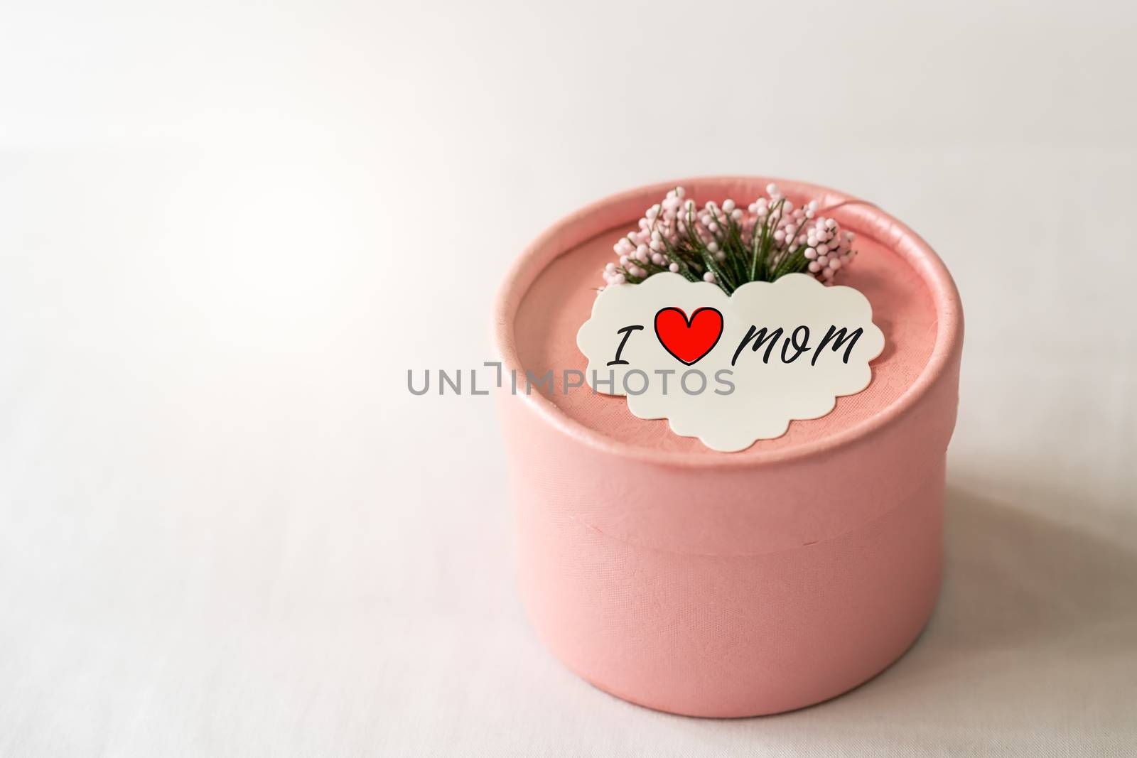Happy mother's day concept. Gift box and flower, paper tag with I LOVE MOM text.