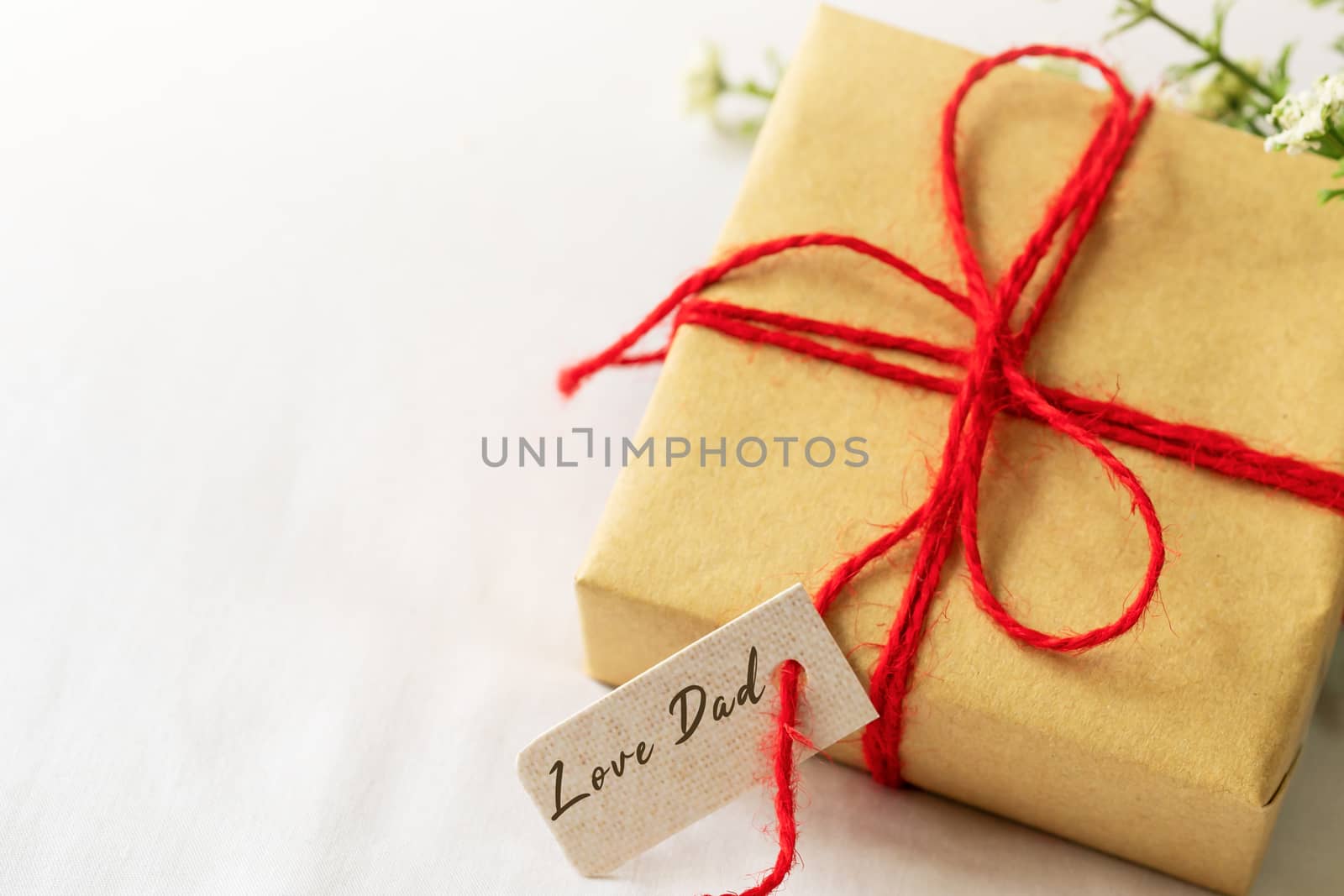 Happy father's day concept. Gift box and flower, paper tag with Love Dad text