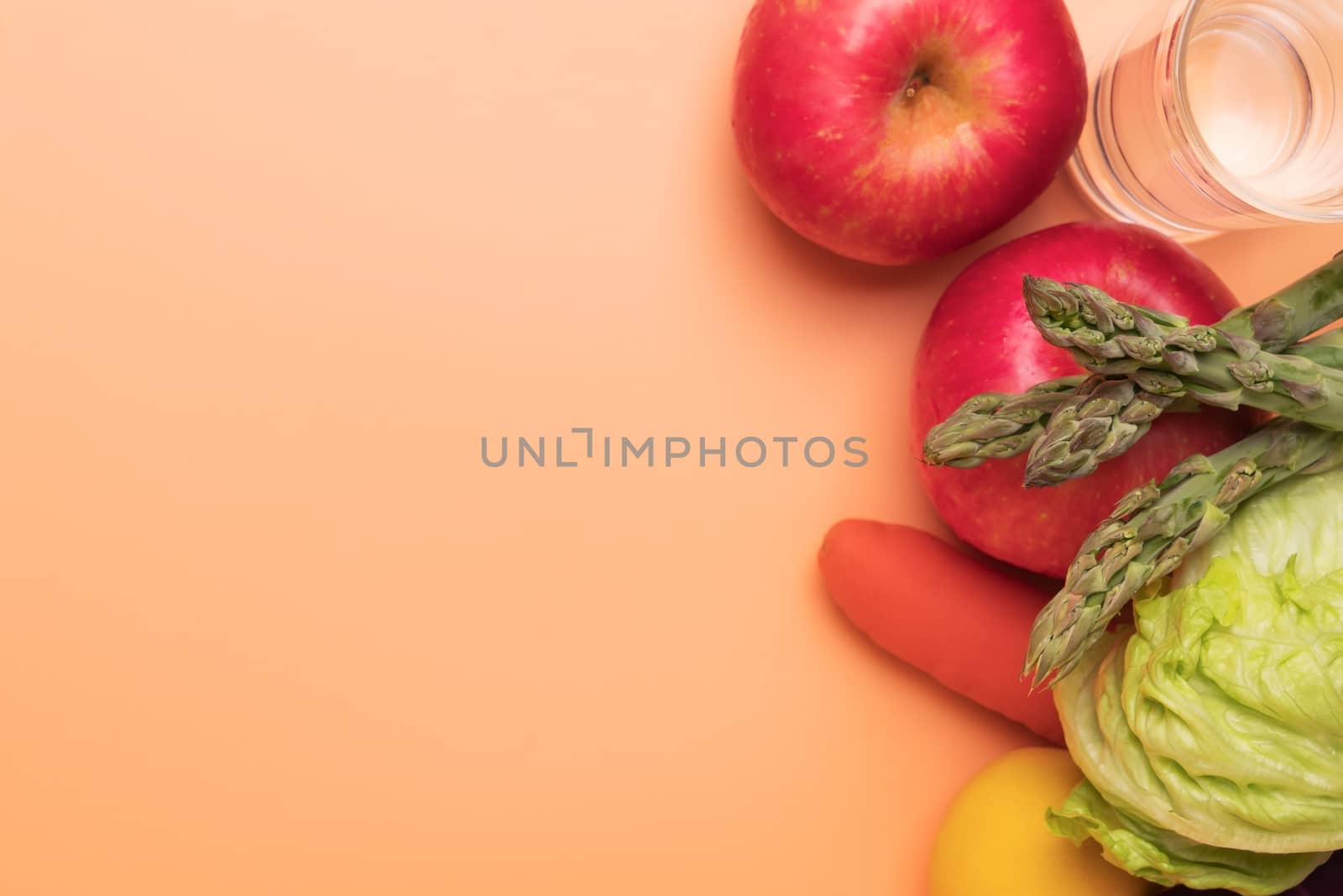 fruit vegetable and glass of water isolated on orange background, healthy food and fitness concept