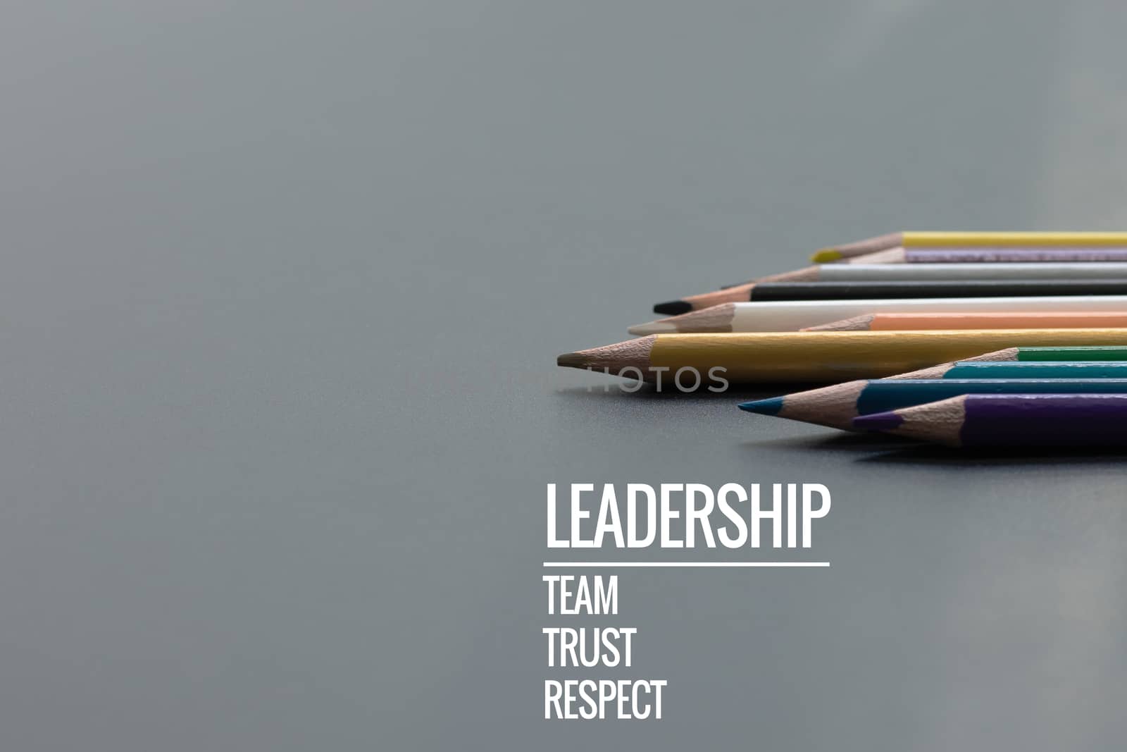 Leadership business concept. Gold color pencil lead other color with word Leadership, team, trust and respect on black background
