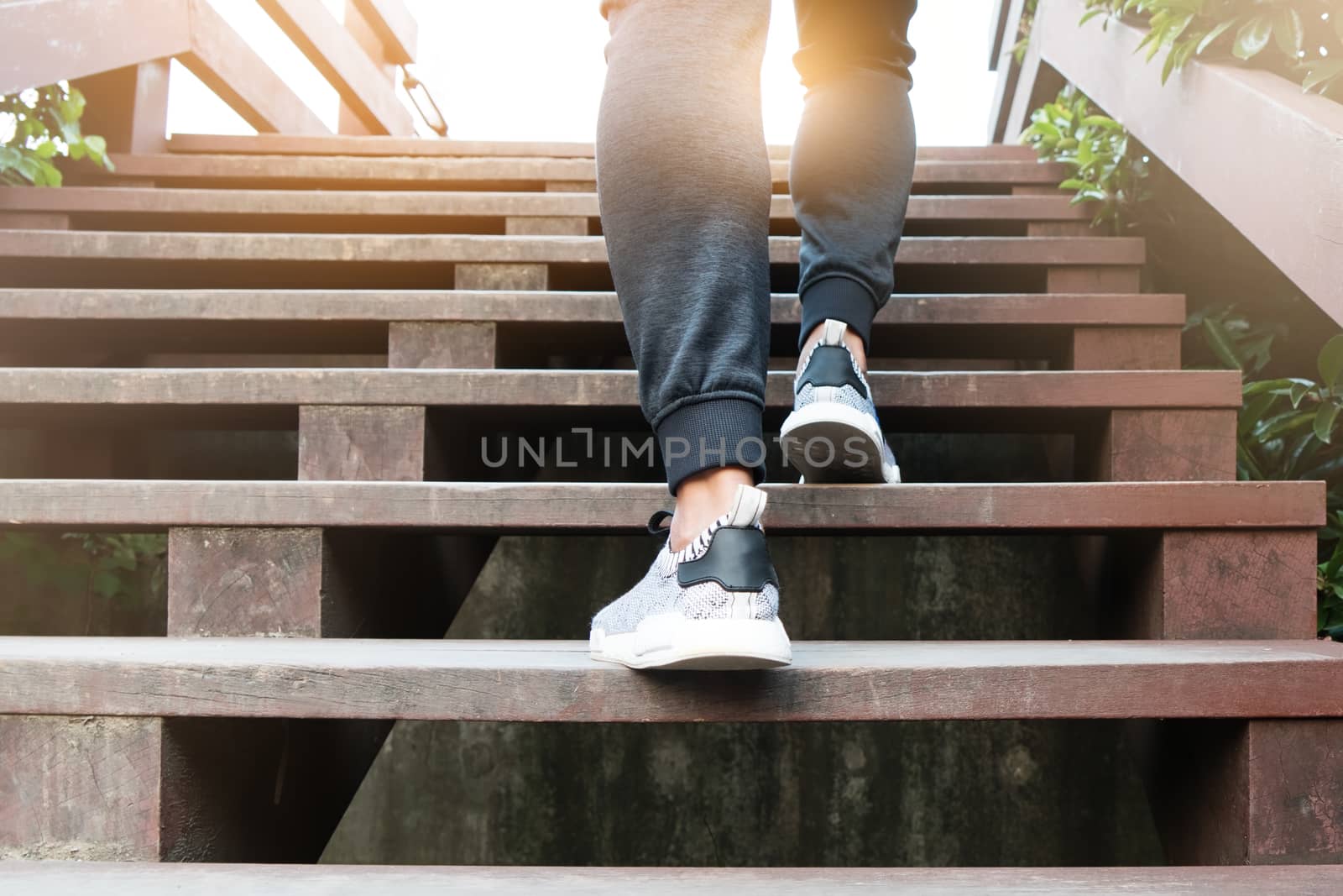 A man step up to success, sport man is climbing on wooden step