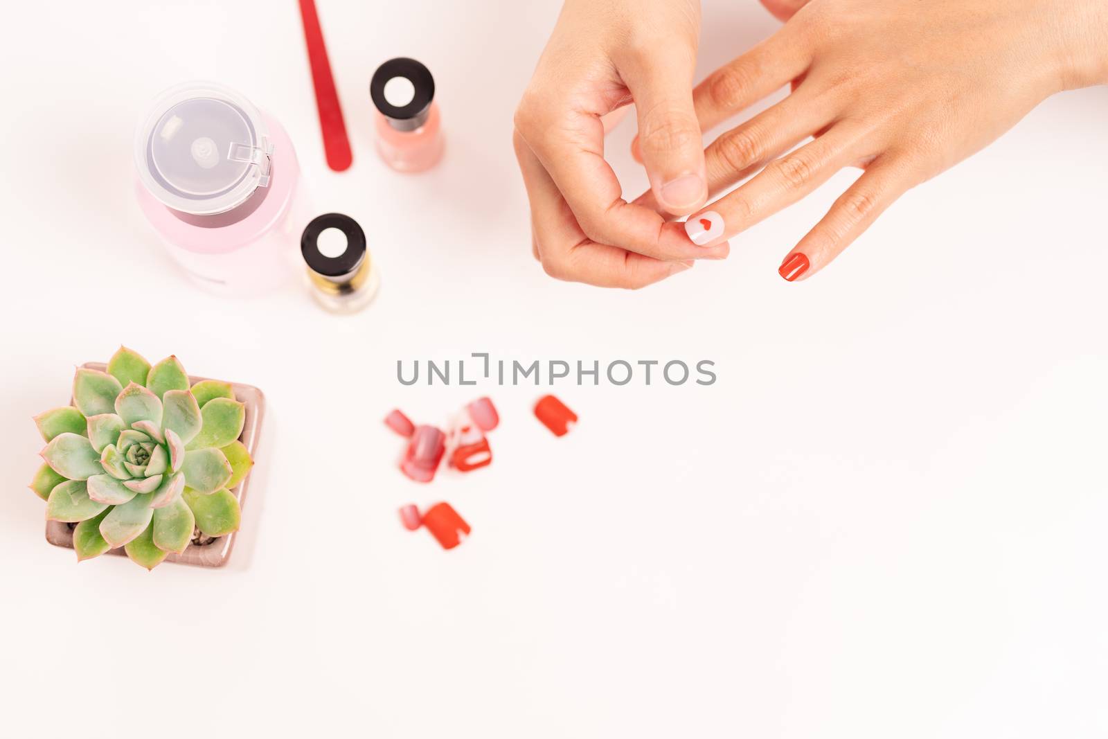 women manicure and attaches a nail shape during the procedure of by psodaz