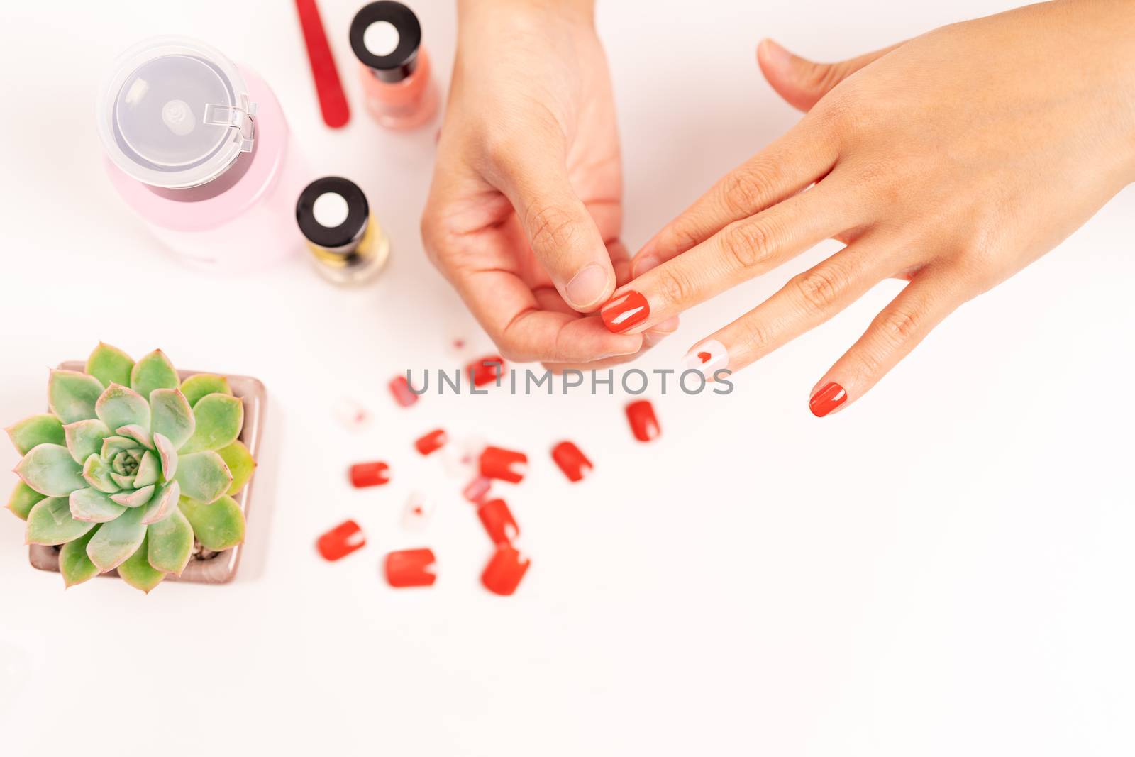 women manicure and attaches a nail shape during the procedure of by psodaz