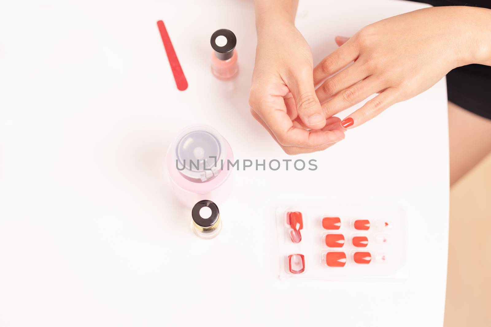 women manicure and attaches a nail shape during the procedure of by psodaz