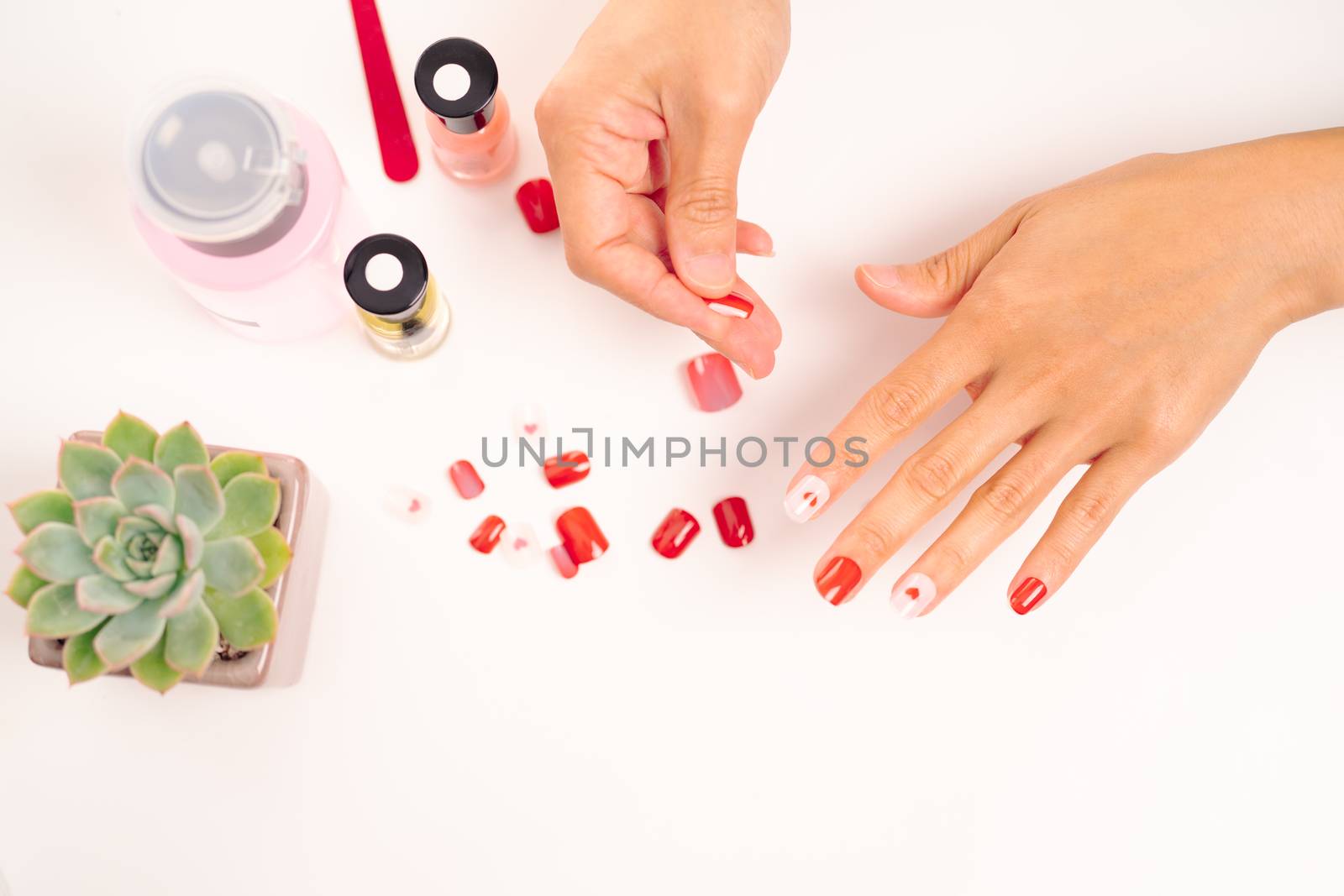 women manicure and attaches a nail shape during the procedure of by psodaz