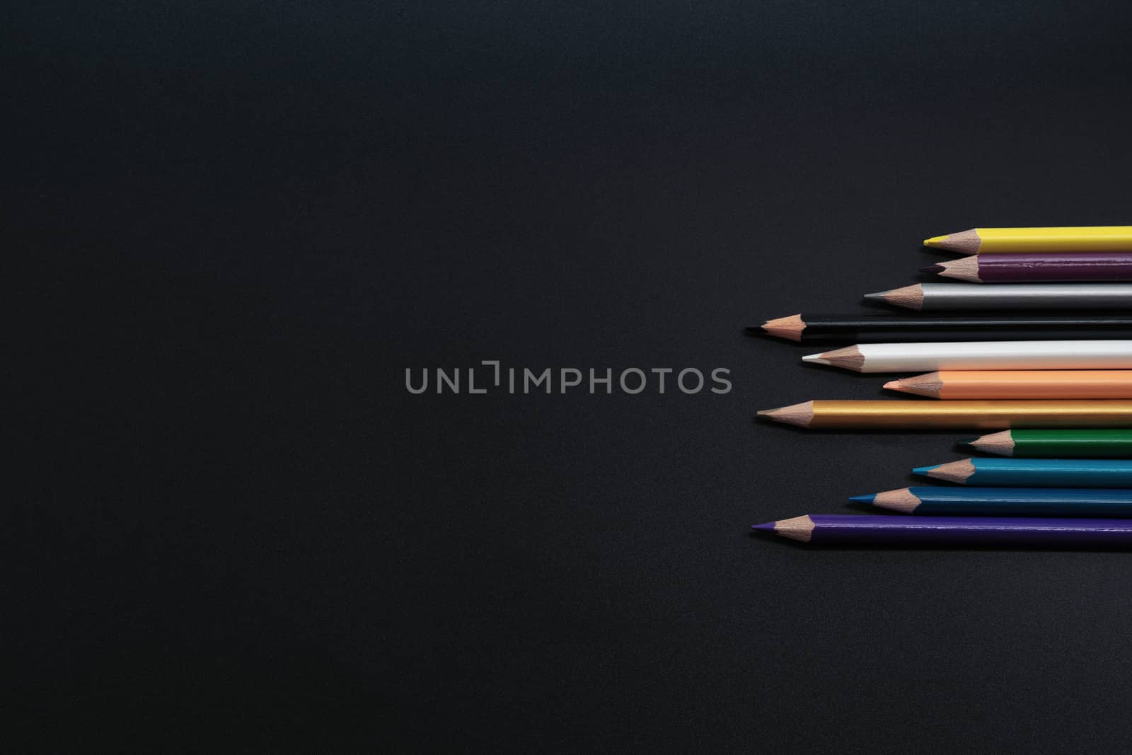 Teamwork concept. group of color pencil on black background by psodaz