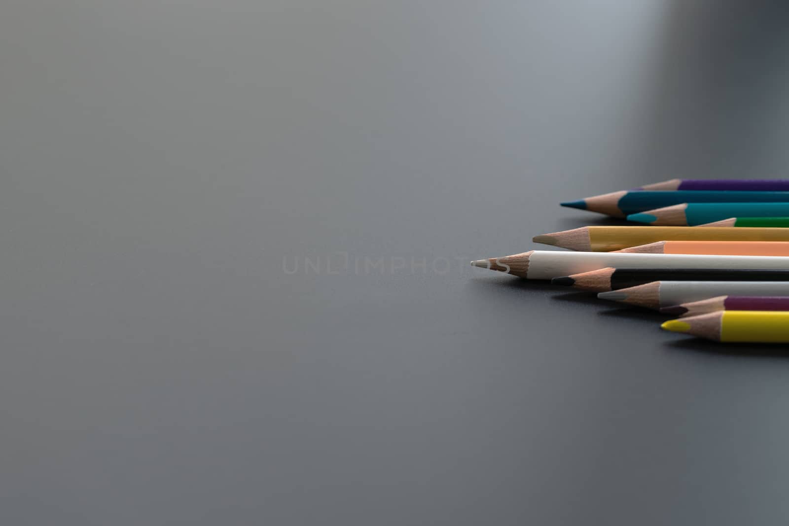 Leadership business concept. white color pencil lead other color on black background