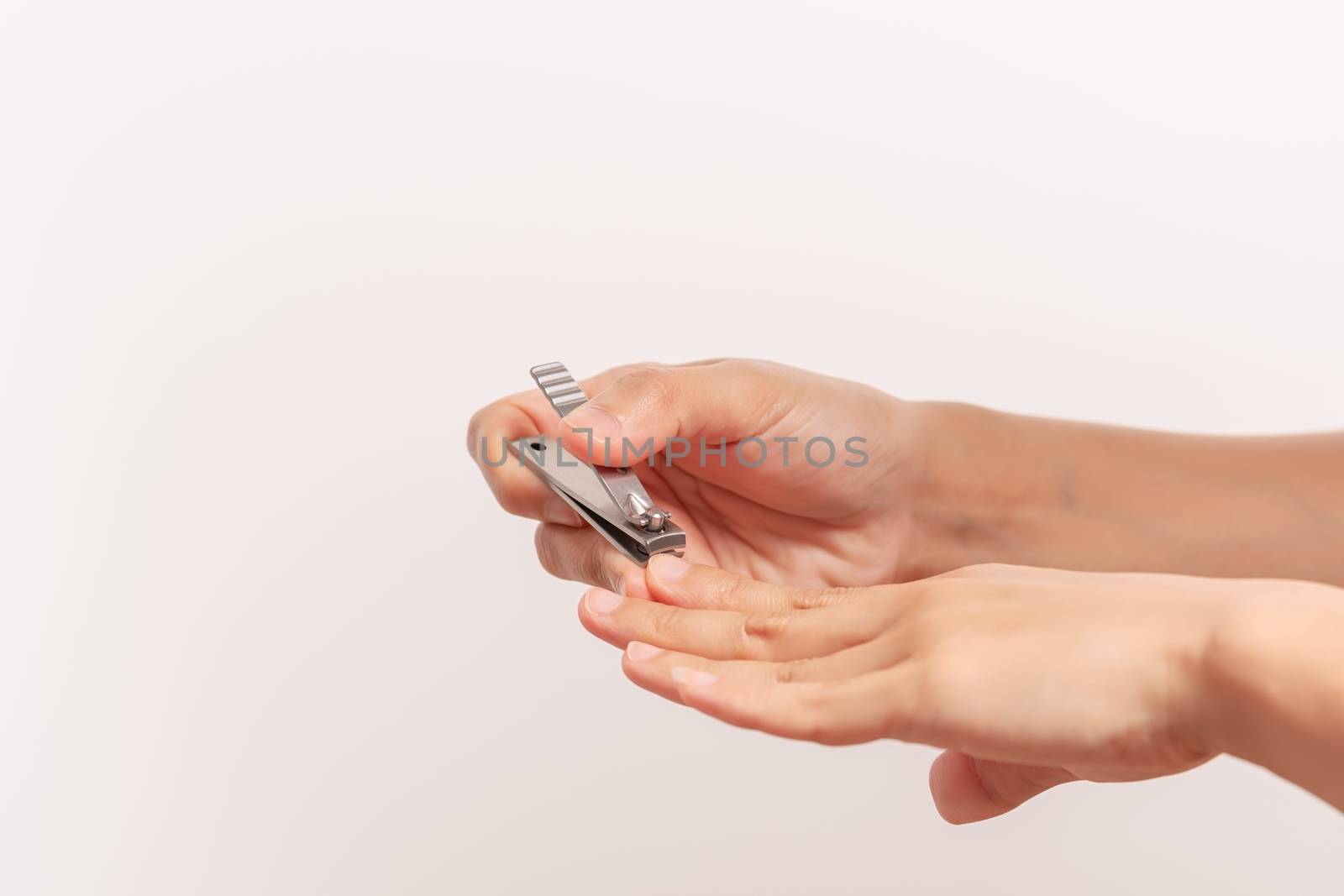 woman hand cutting nails using nail clipper on white backgrounds