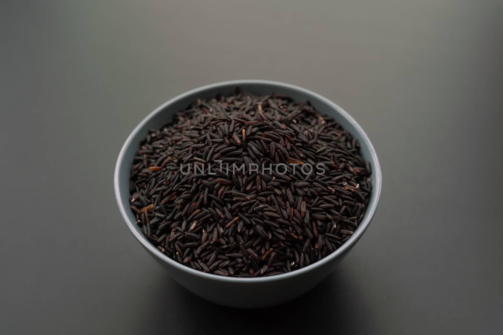 bowl of jasmine black rice on black backgrounds by psodaz