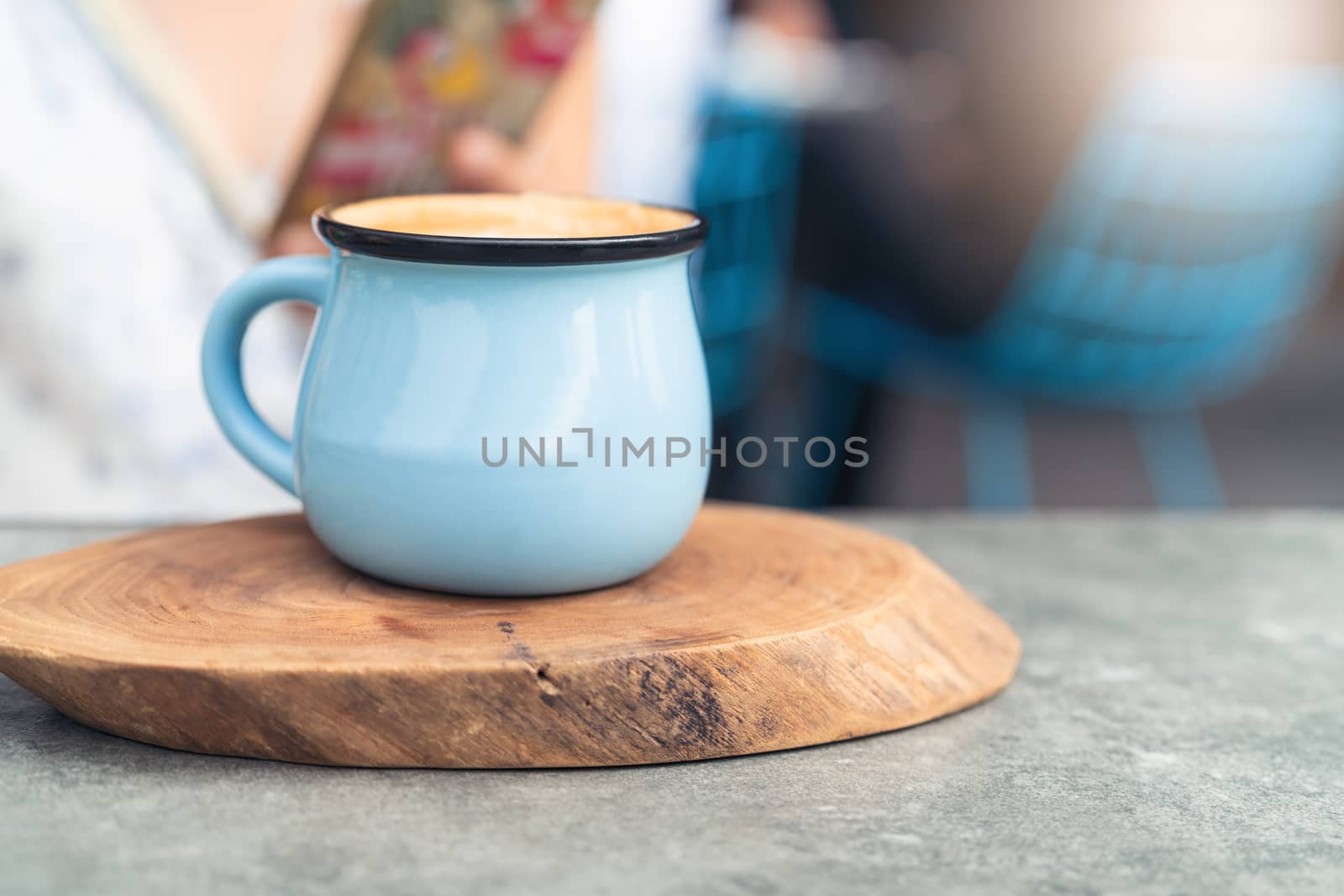 Coffee cup in blue glass on wooden plate