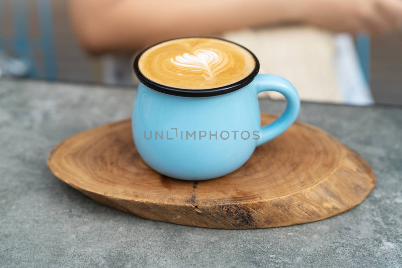 Coffee cup in blue glass on wooden plate