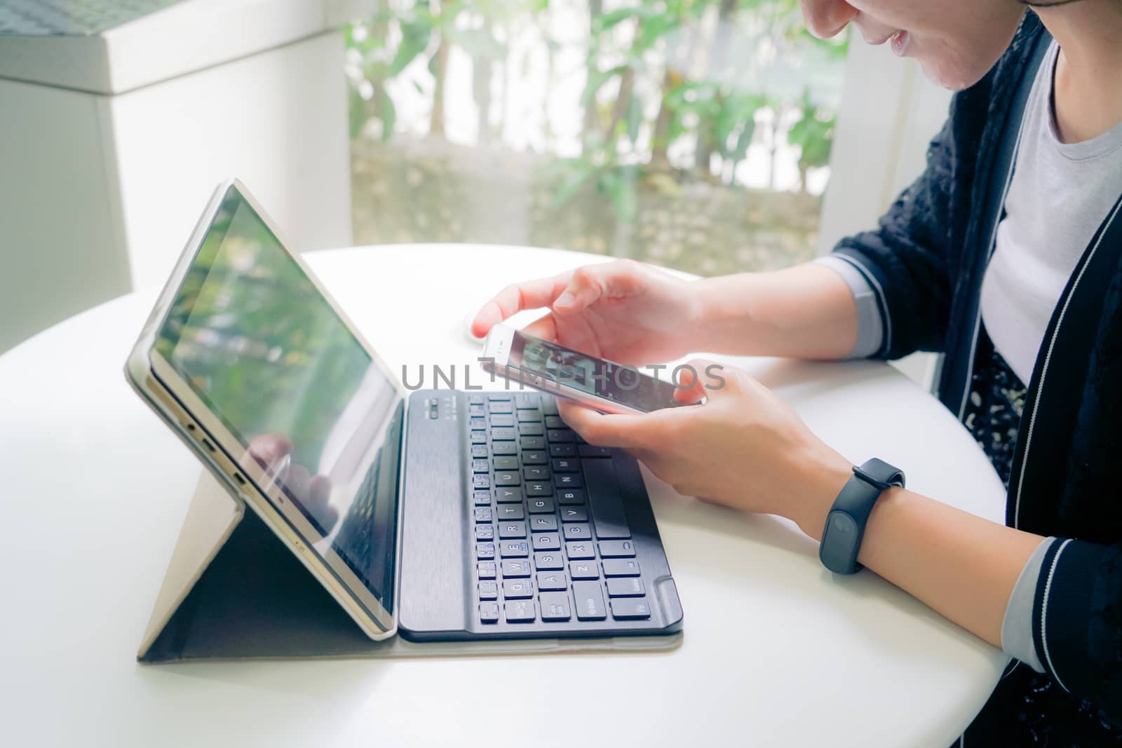 Young student women wearing smart band focus on her tablet computer and smart phone