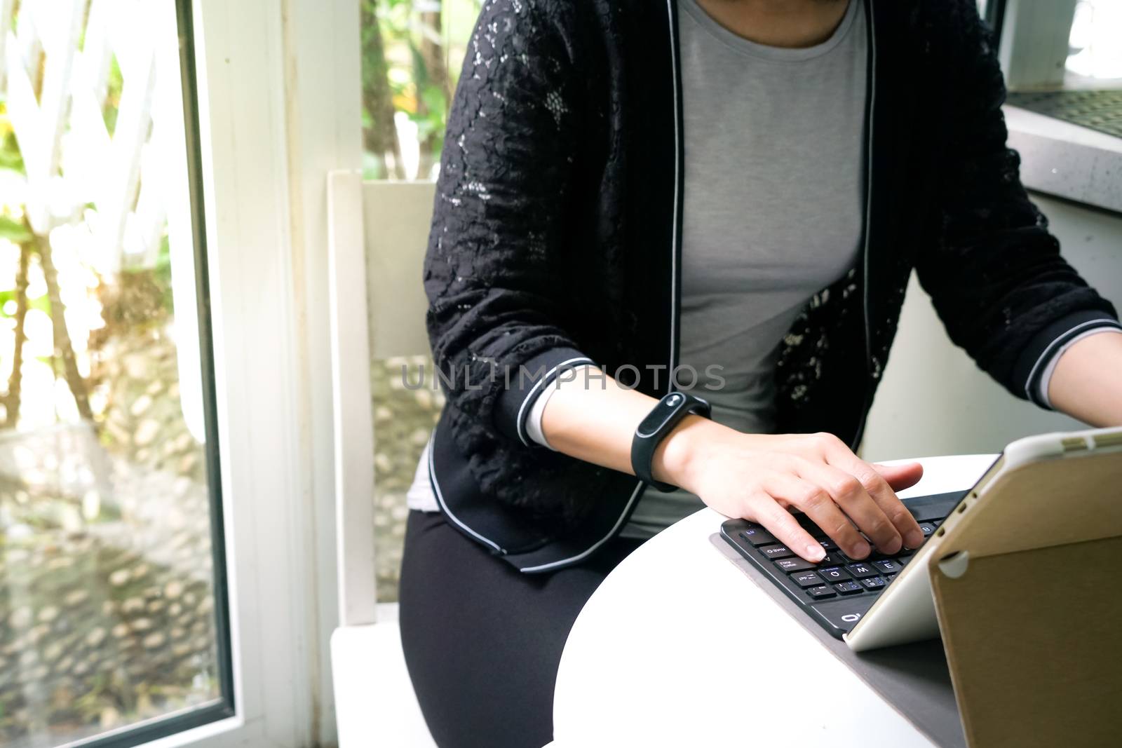 Young student women wearing smart band focus on her tablet compu by psodaz