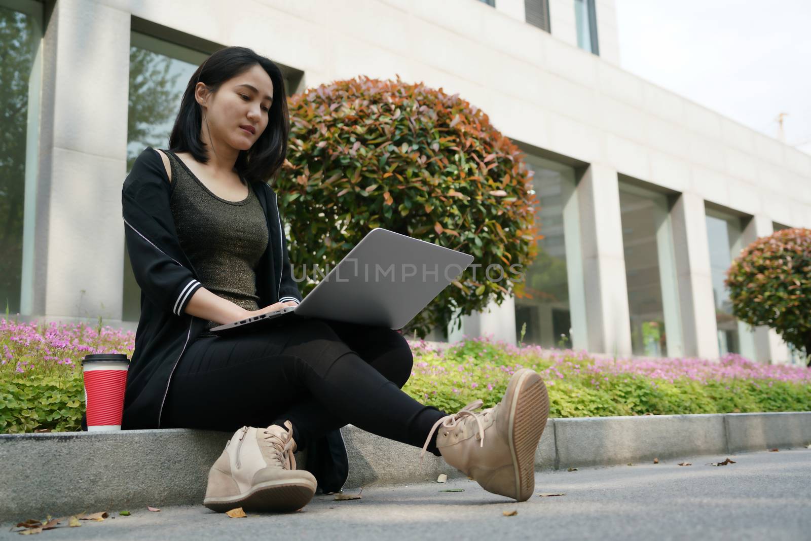 A student woman is typing on laptop computer by psodaz