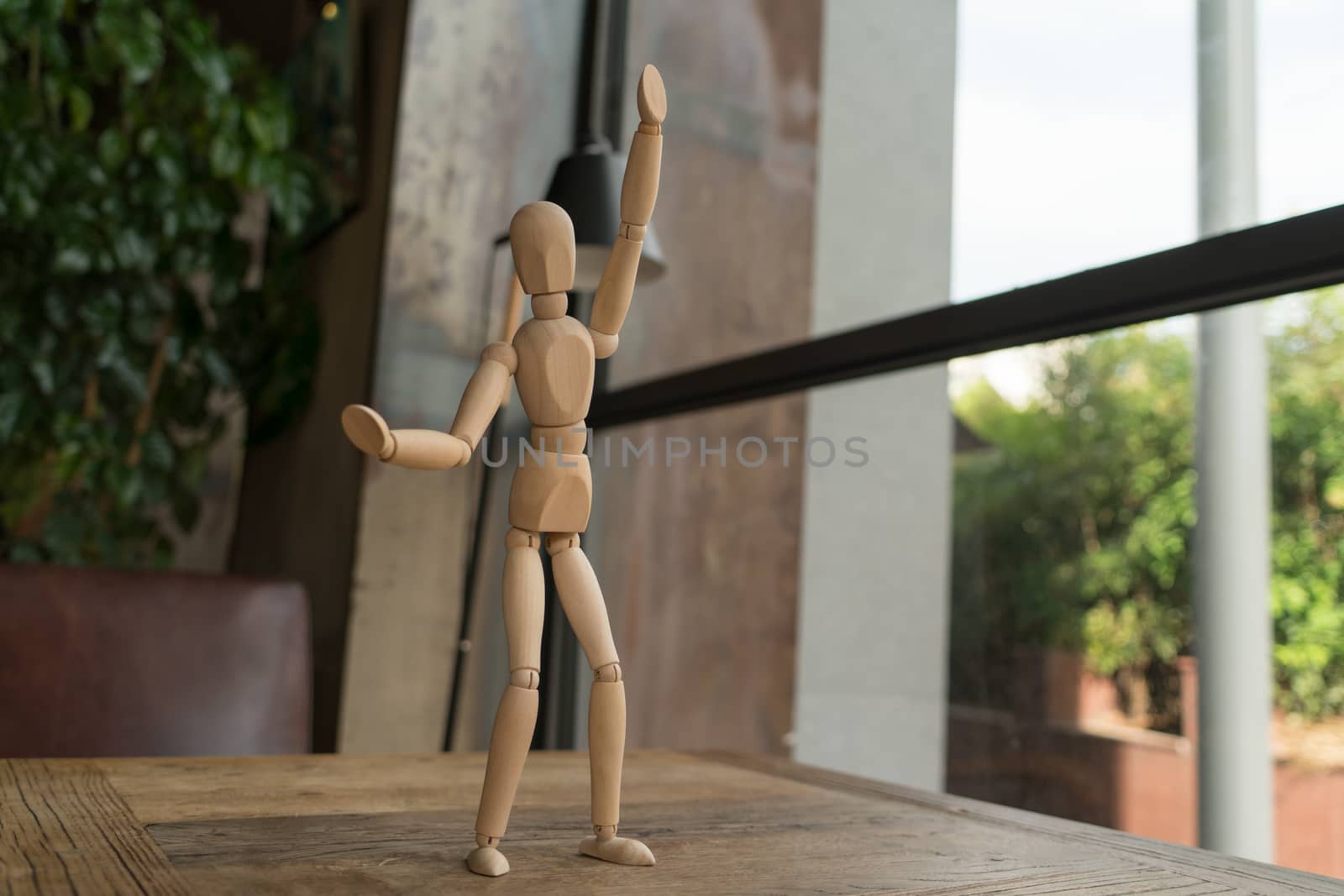 wood man is standing and raise the hand up