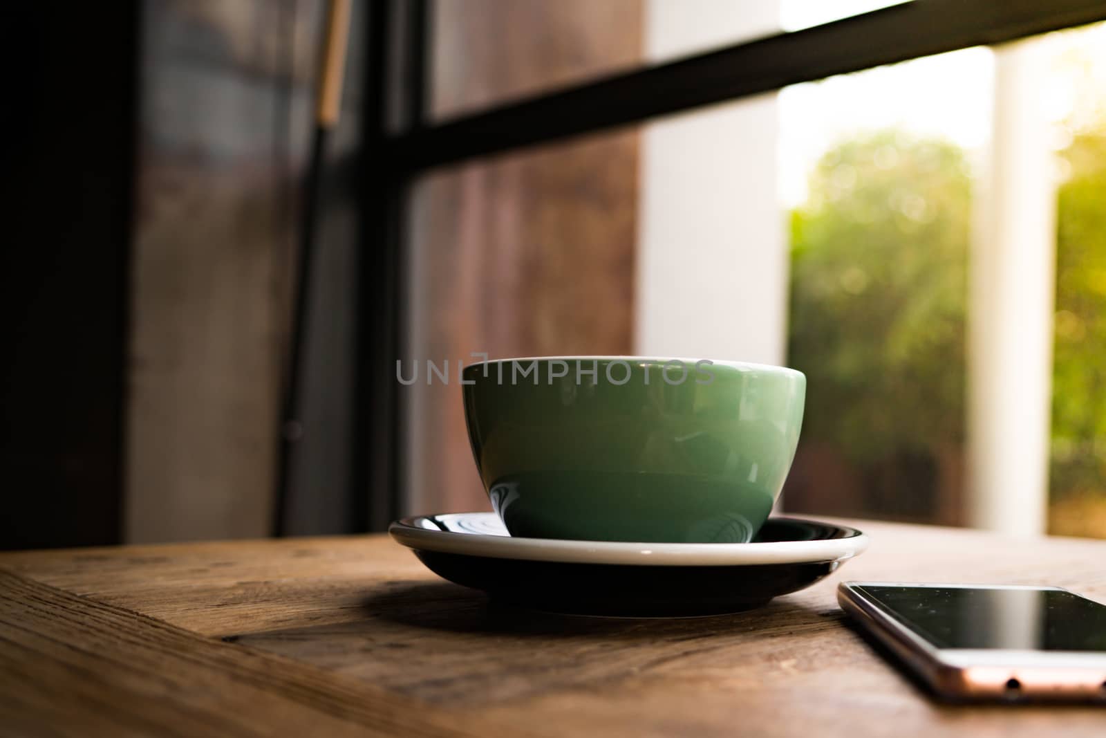 A coffee cup with the smart phone on the wooden table by psodaz