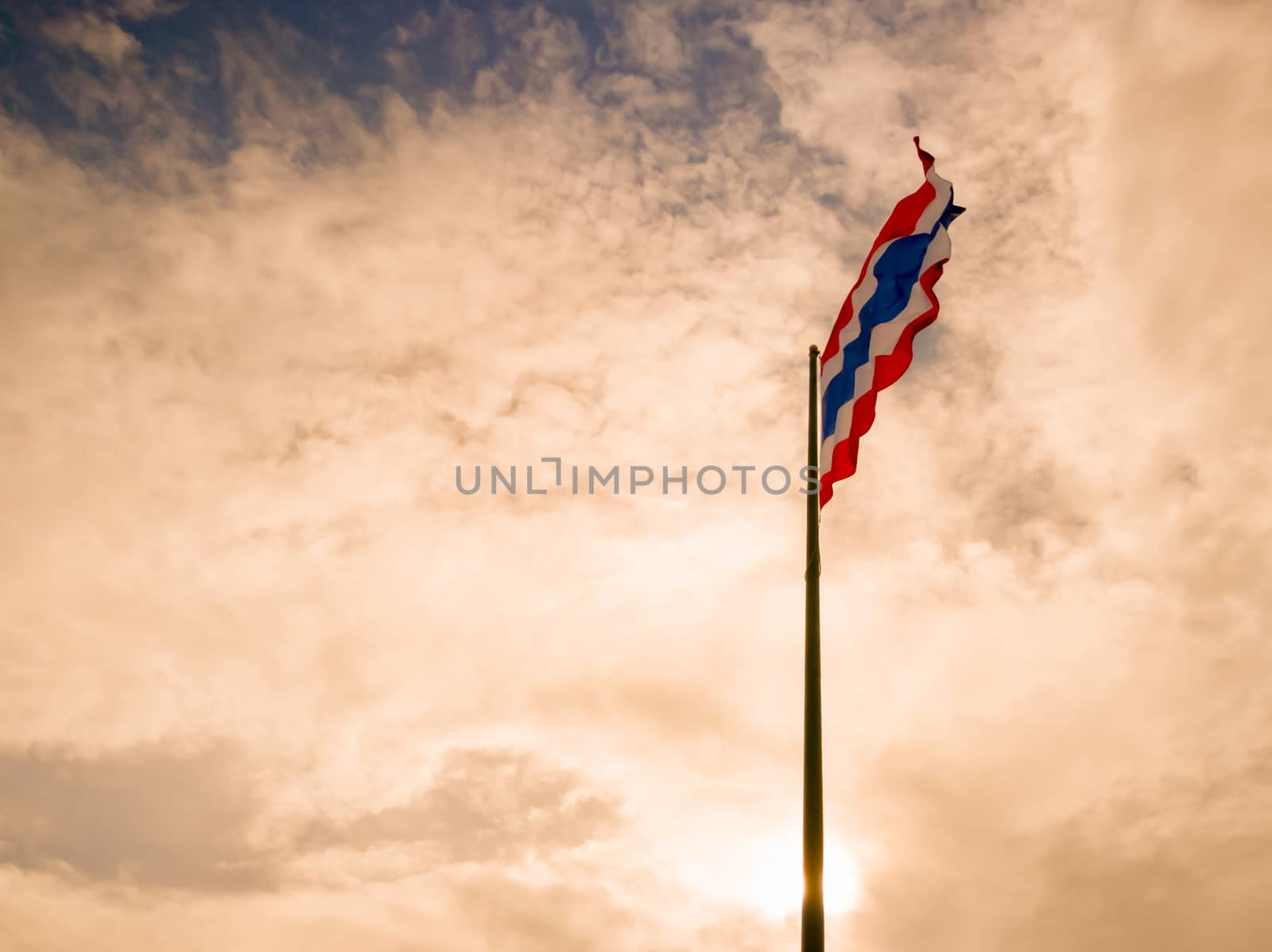 The sunrise sky with Thai flag blowing in the wind