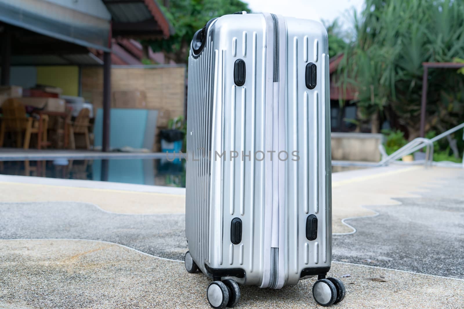 The silver travelling luggage is ready for summer beach and pool