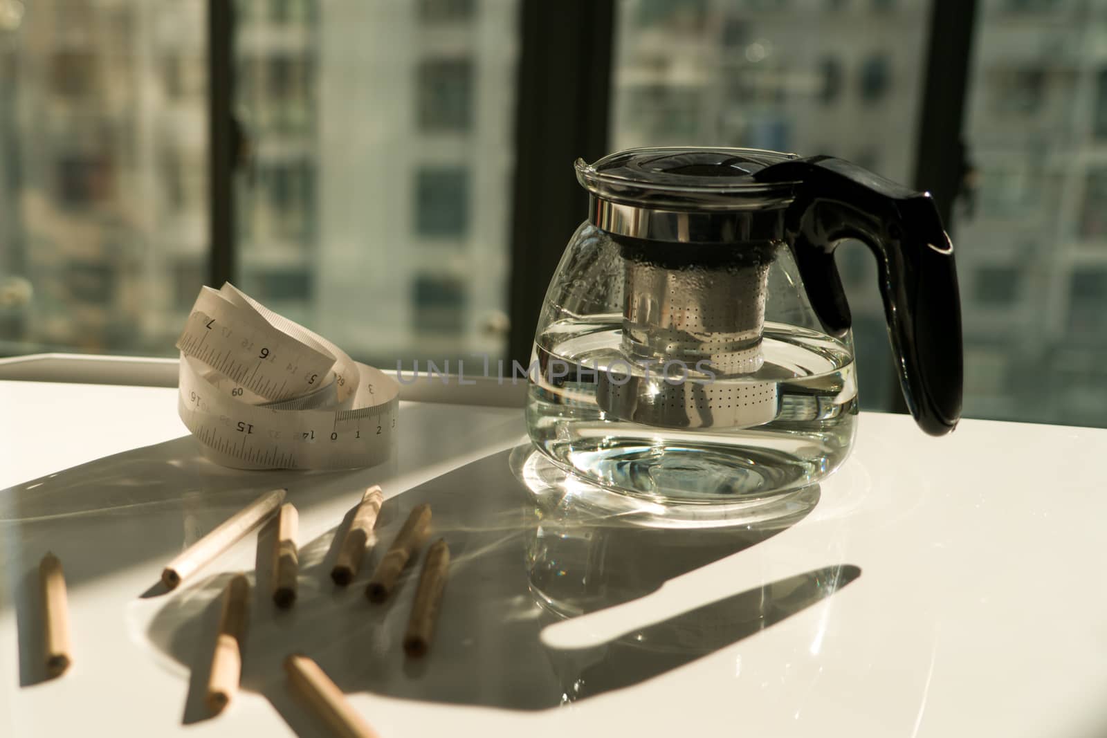 tea pot with measure tape and pencil on the working table, working and rest concept