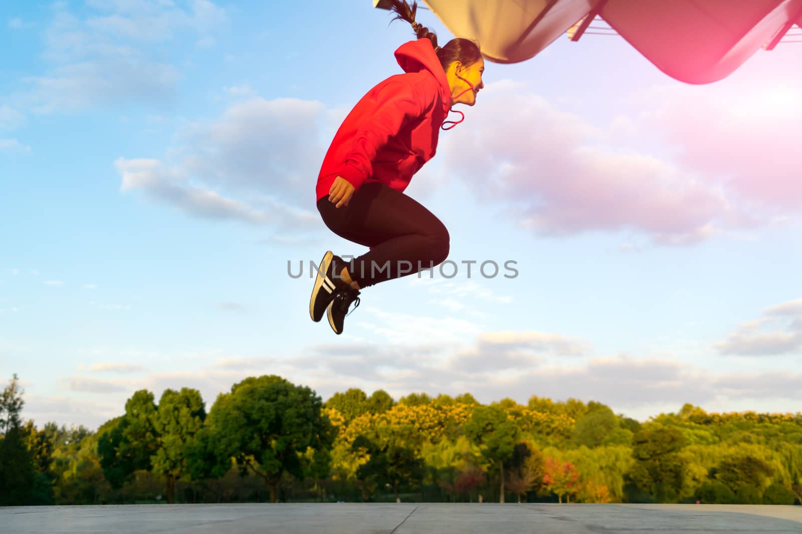 happy young woman is jumping over the garden - applier sunbeam by psodaz