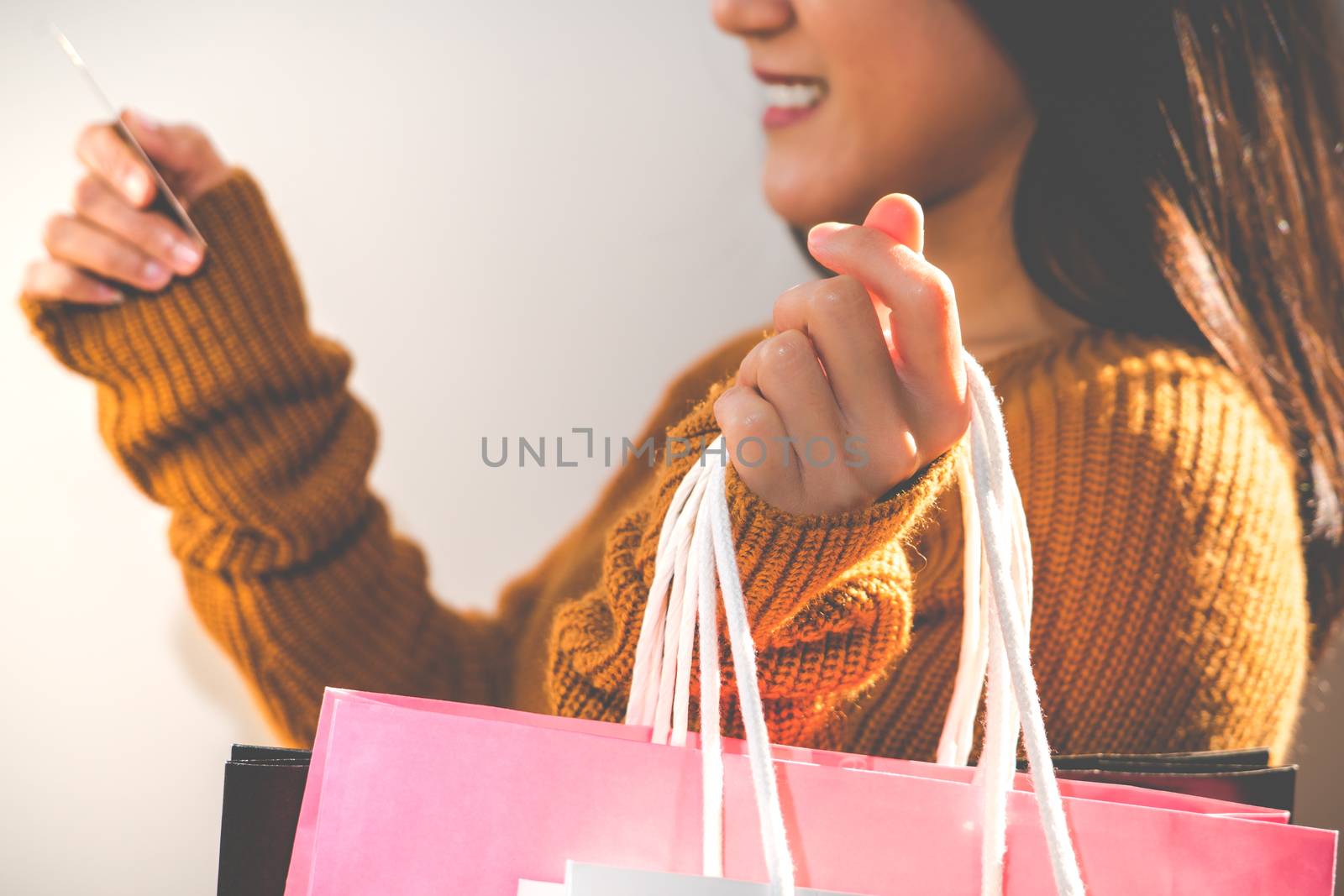 Happy girl holding the colorful shopping bag and credit card for family new year gift - applied matt soft focus filter