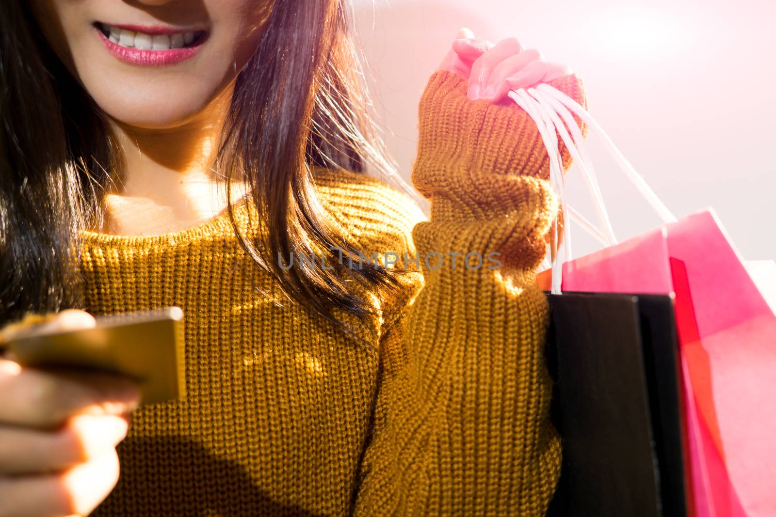 Happy girl holding the colorful shopping bag and credit card for by psodaz