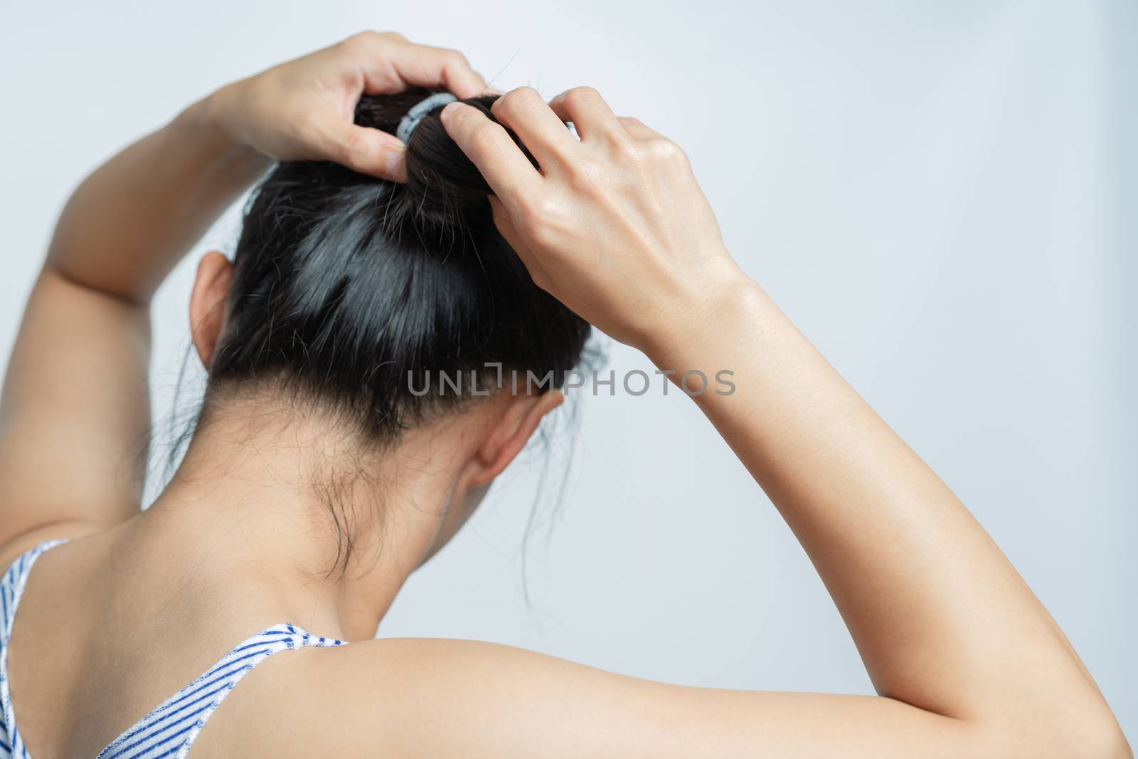 rear view of women tightening the hair, lifestyle concept