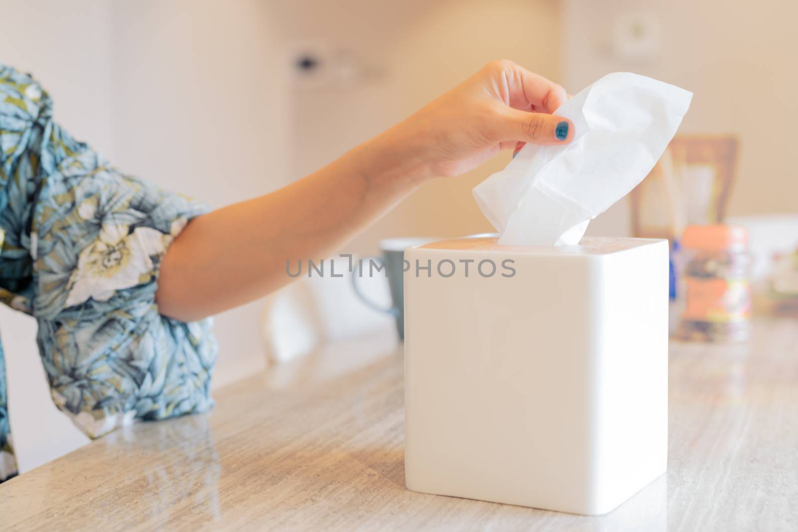 women hand picking napkin/tissue paper from the tissue box