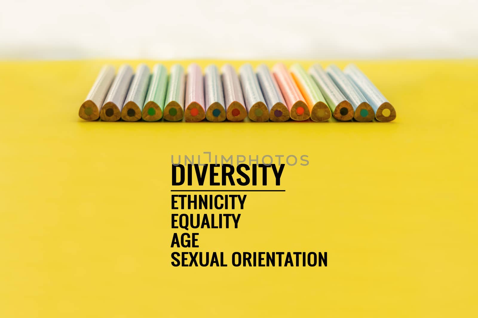 Diversity concept. row of mix color pencil on yellow background with text Diversity, Ethnicity, Equality, Age, Sexual Orientation