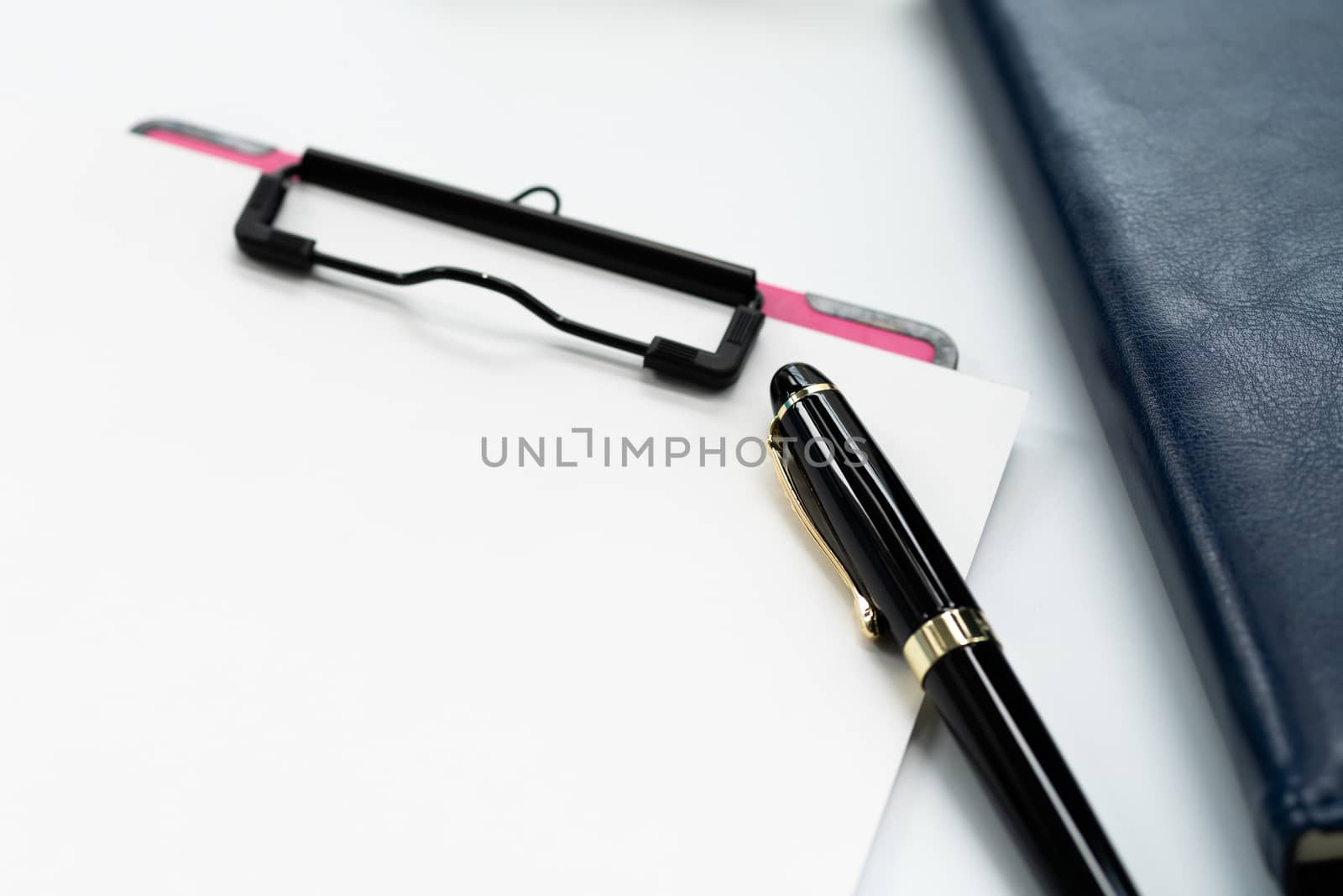 pen and clipboard with blank sheet, glasses on diary book on white background with copy space