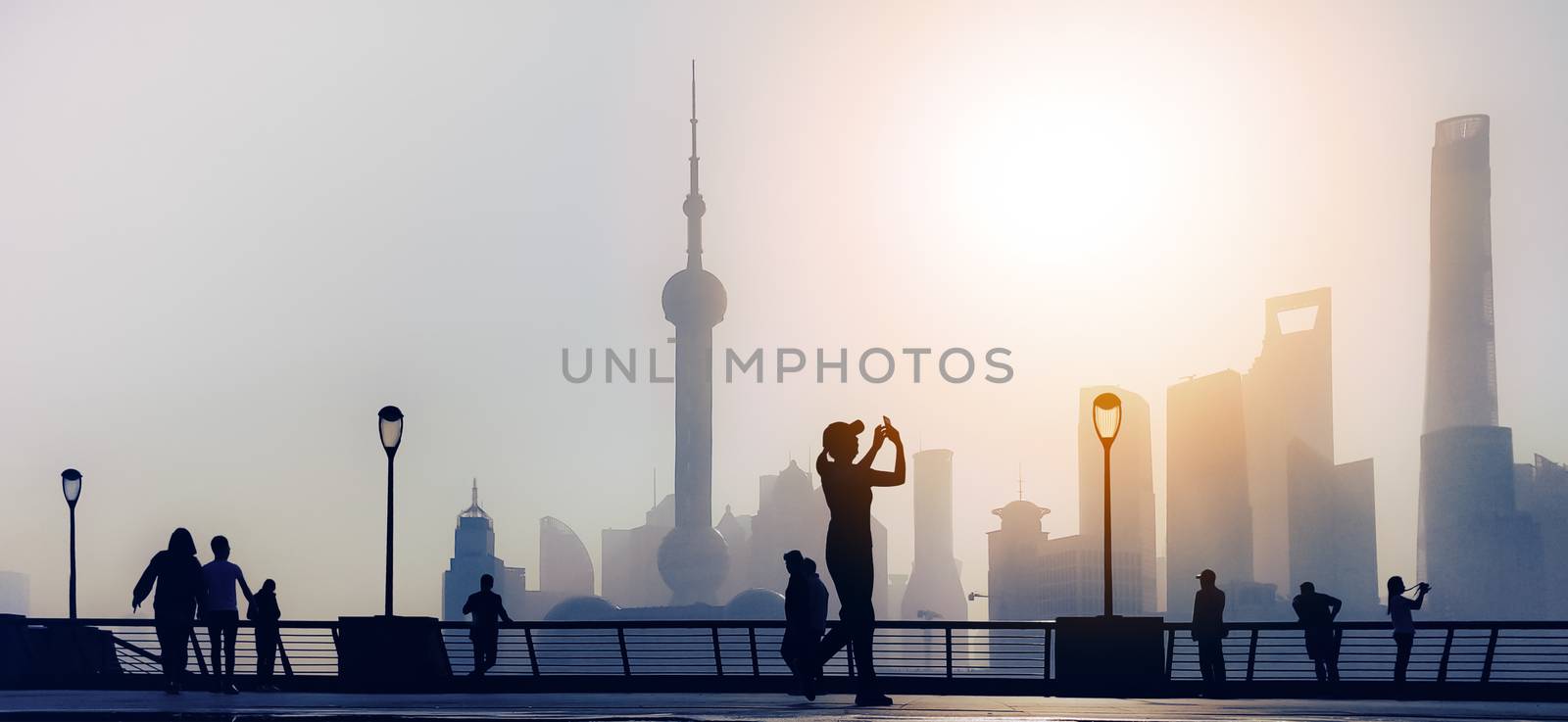 traveler take a photo of morning activity at the bund, huangpu riverside,  shanghai city view background