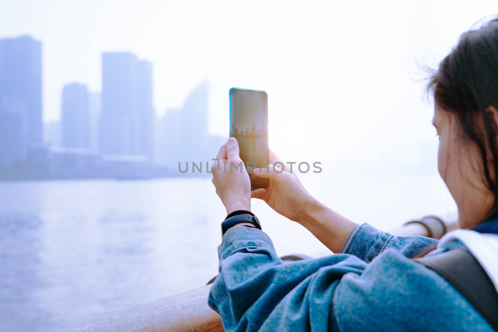 Cityscape on smartphone. View through the screen at Shanghai City on women screen, China.