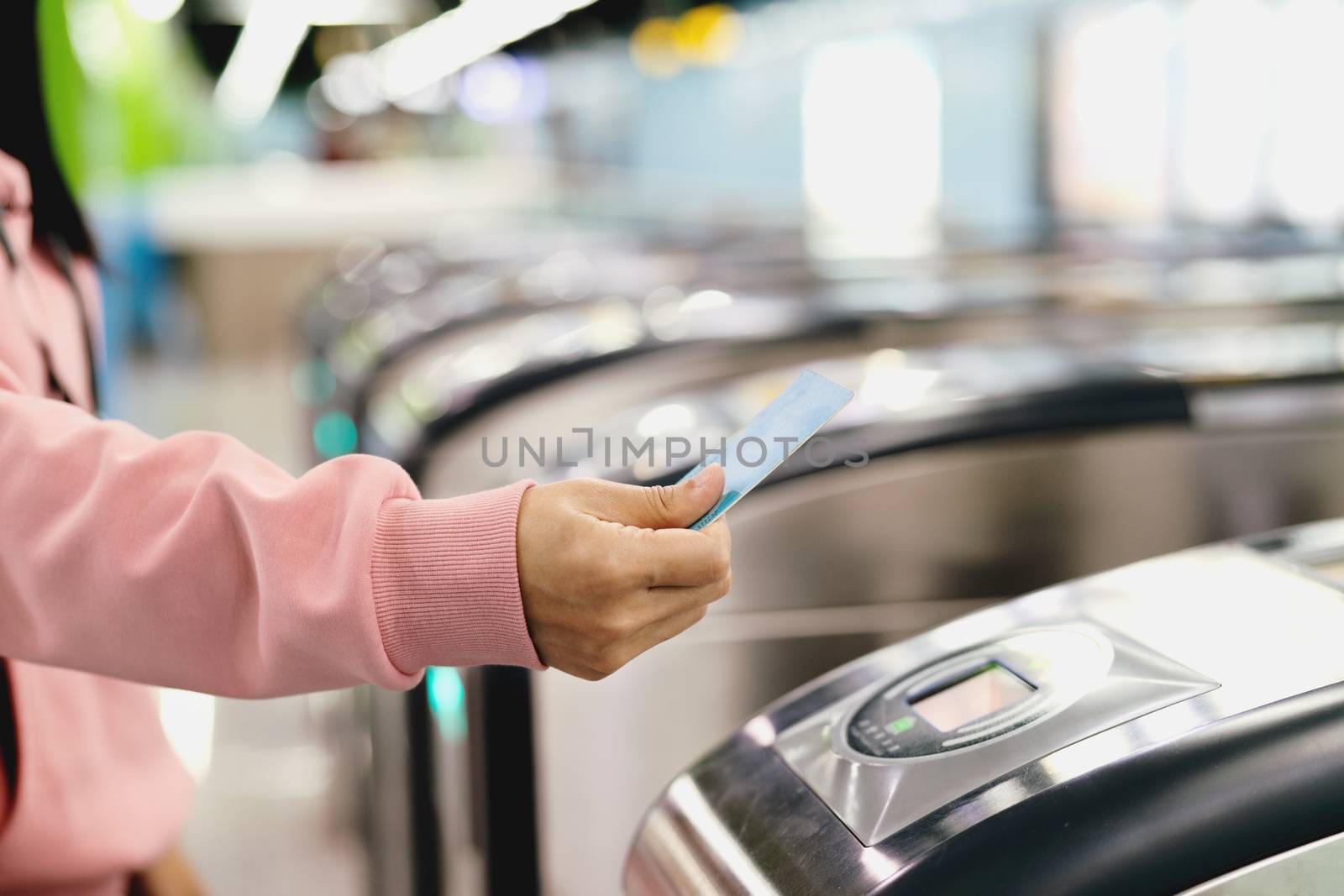 Woman hand scanning train ticket to subway entrance gate. Transp by psodaz