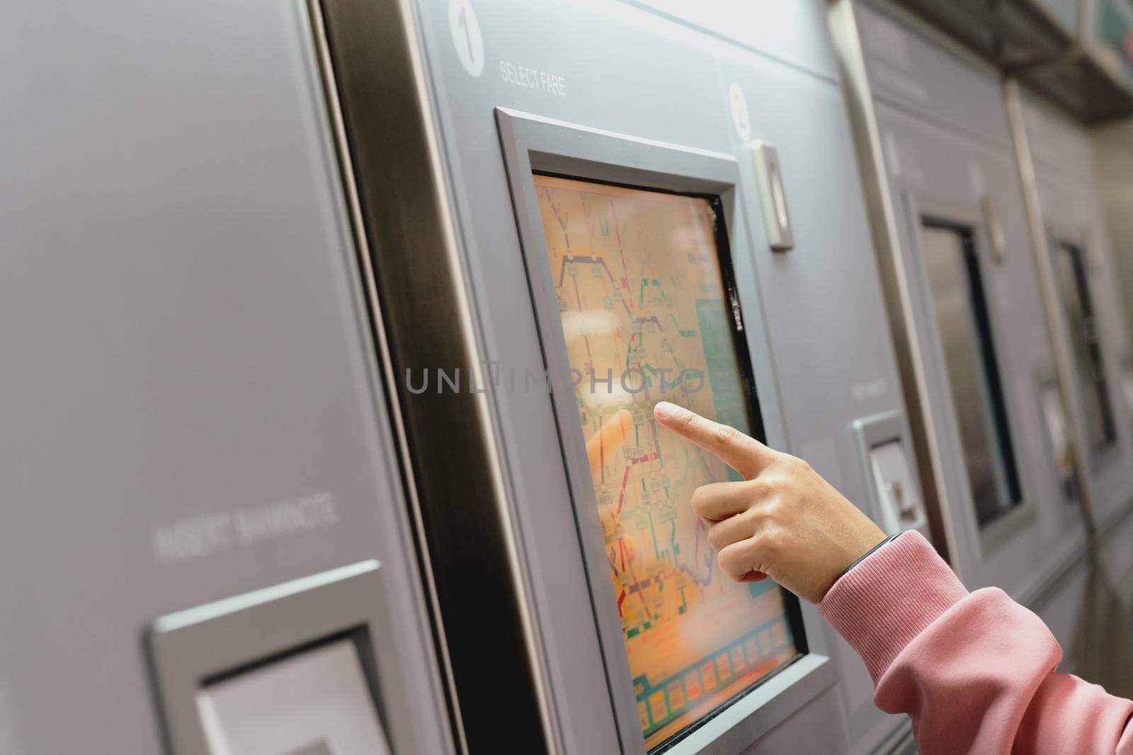 Woman choosing the destination on subway train ticket machine. Transportation concept