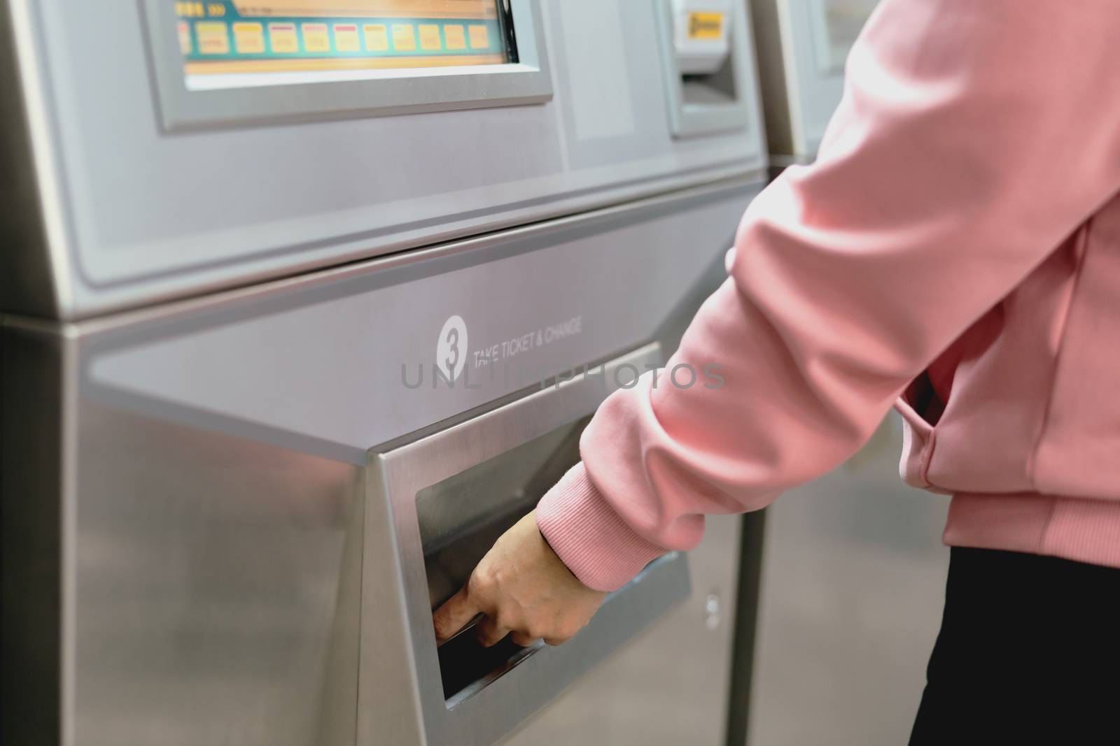 Woman take a train ticket after buy from subway ticket machine.  by psodaz