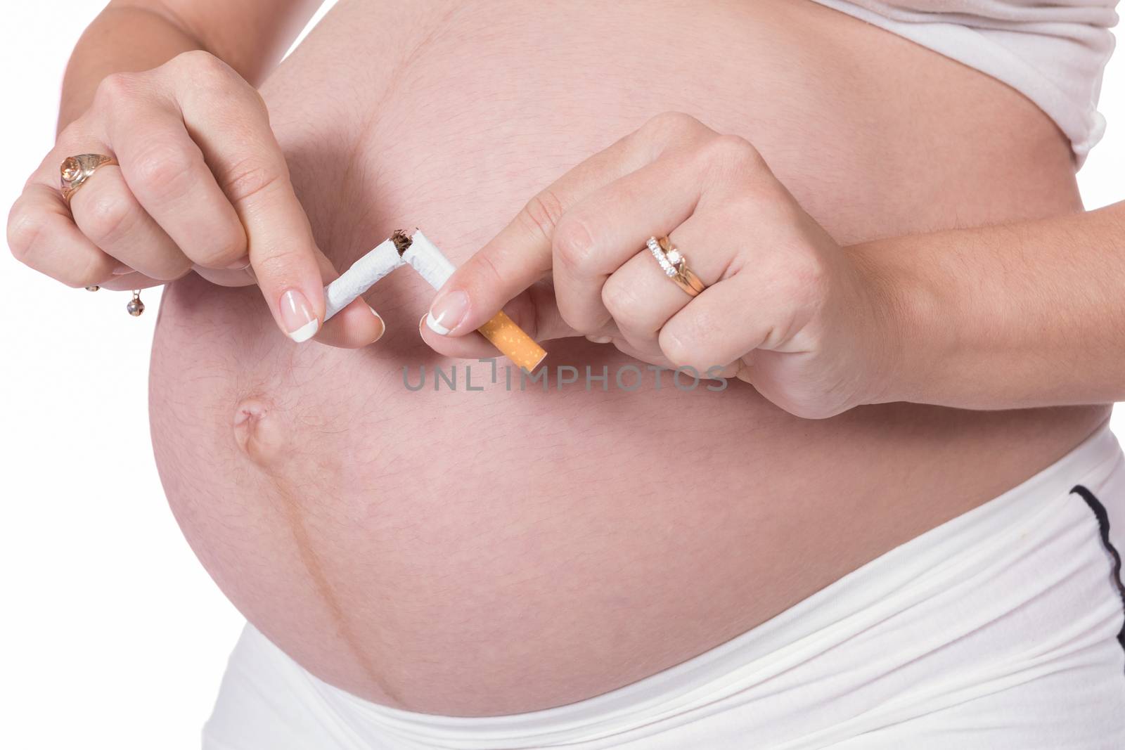 Pregnant woman breaking a cigarette with her hands