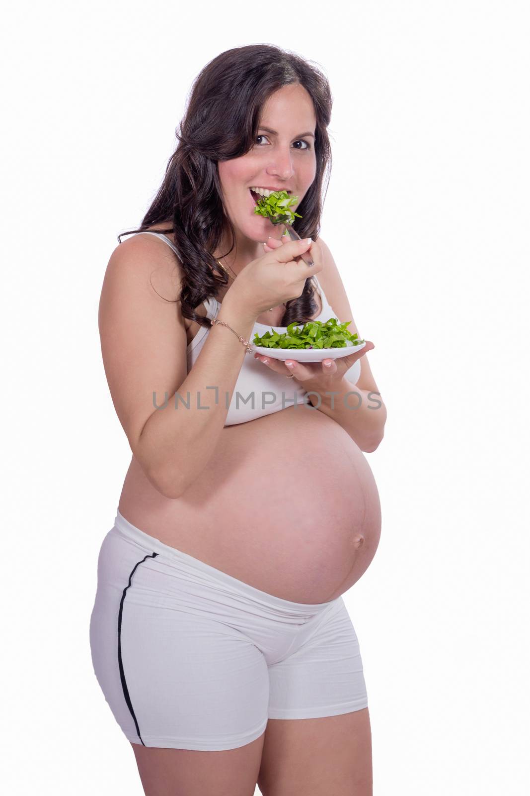 A pregnant woman with to eating salad and wearing white clothes.