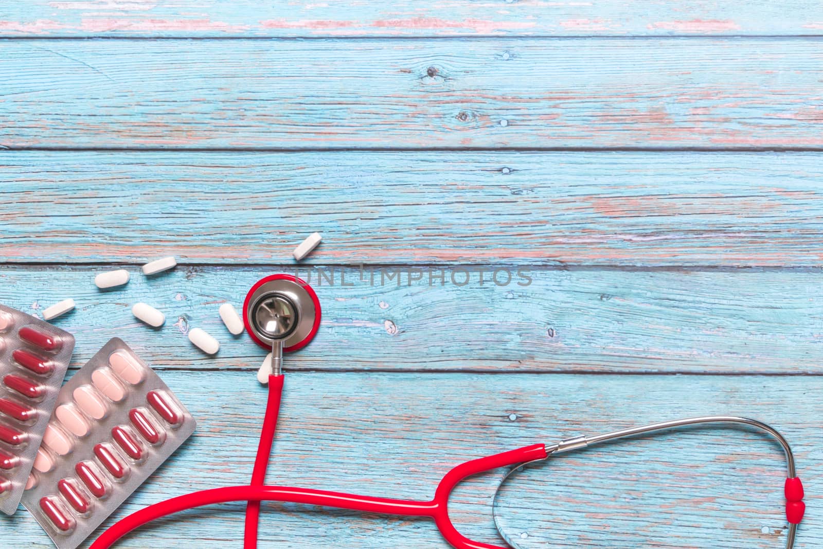 World health day healthcare and medical concept red stethoscope and medicine on the blue wooden background