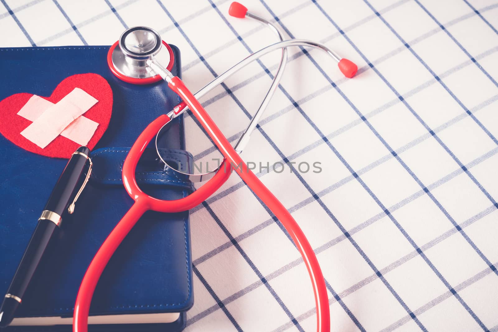 World health day healthcare and medical concept red stethoscope and red heart shape on the blue daily notebook