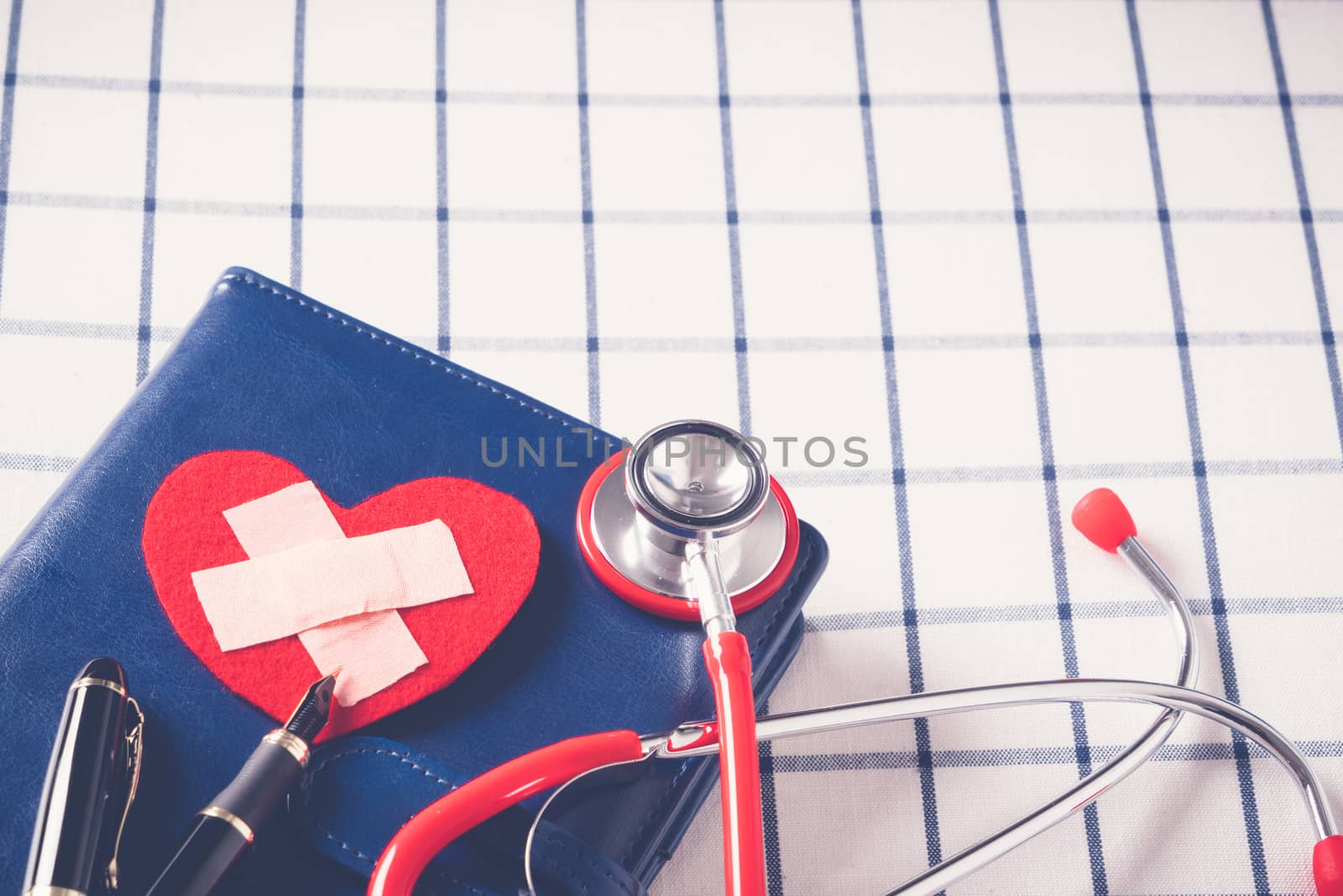 World health day healthcare and medical concept red stethoscope and red heart shape on the blue daily notebook