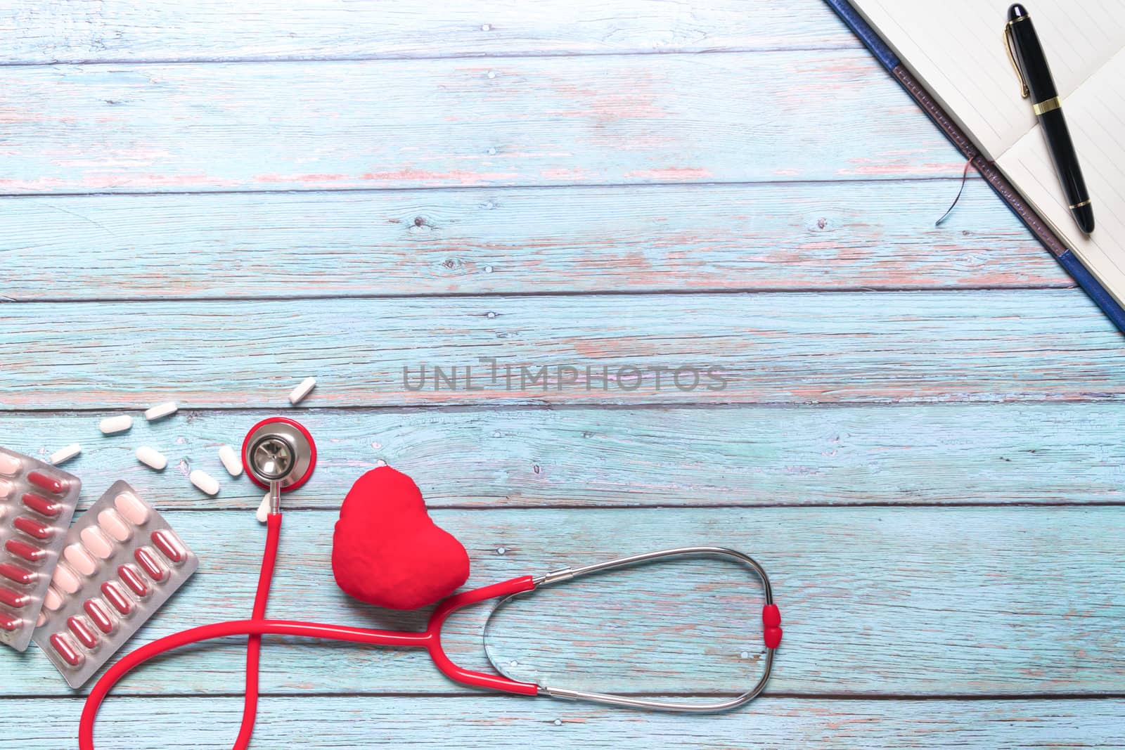 World health day healthcare and medical concept red stethoscope and medicine on the blue wooden background