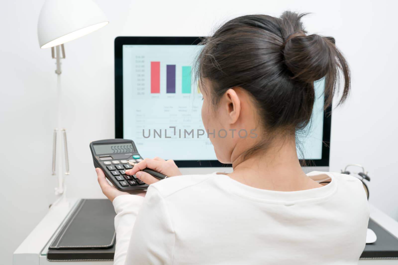 young business women work with calculator and computer desktop and pen on the modern work table