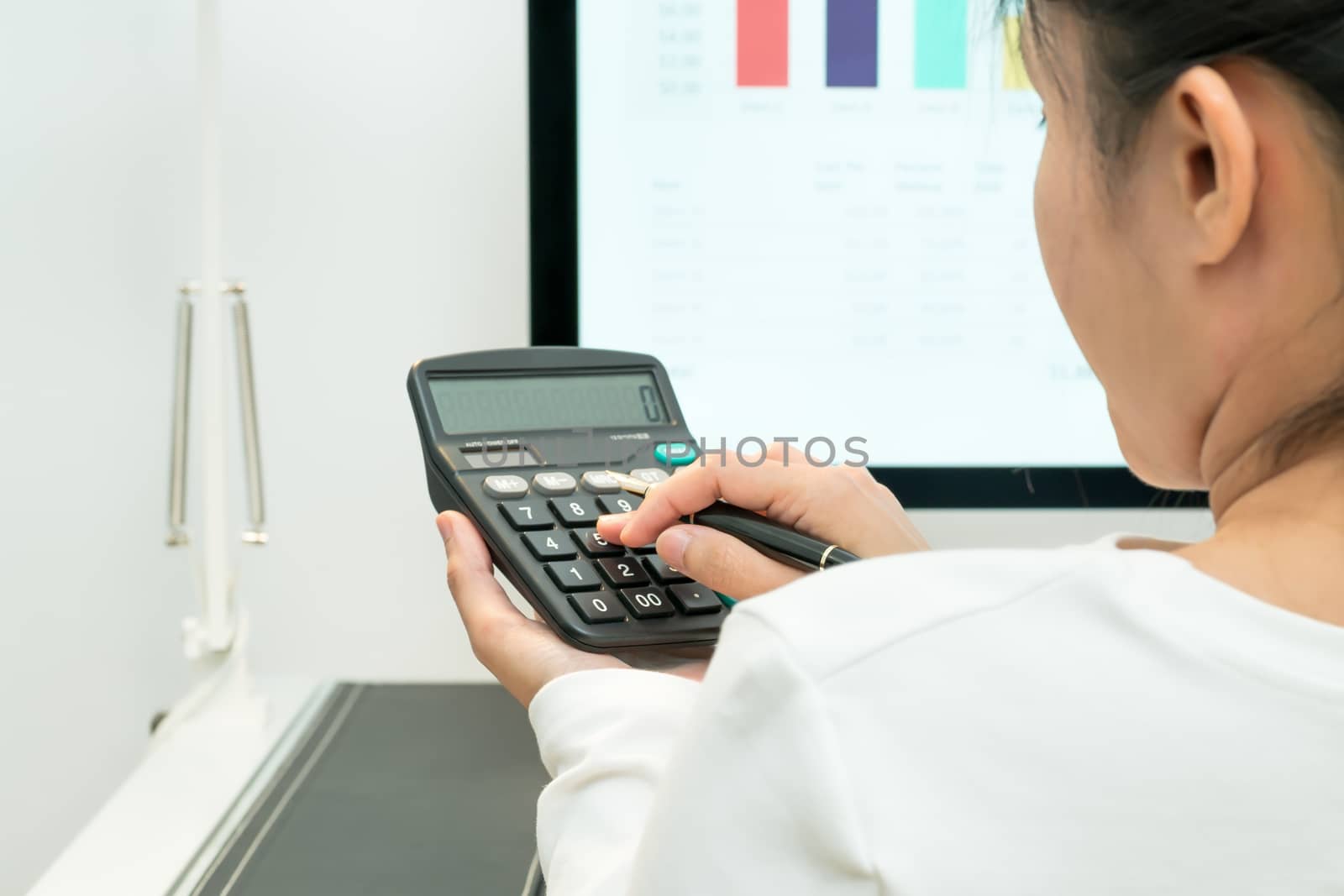 young business women work with calculator and computer desktop and pen on the modern work table