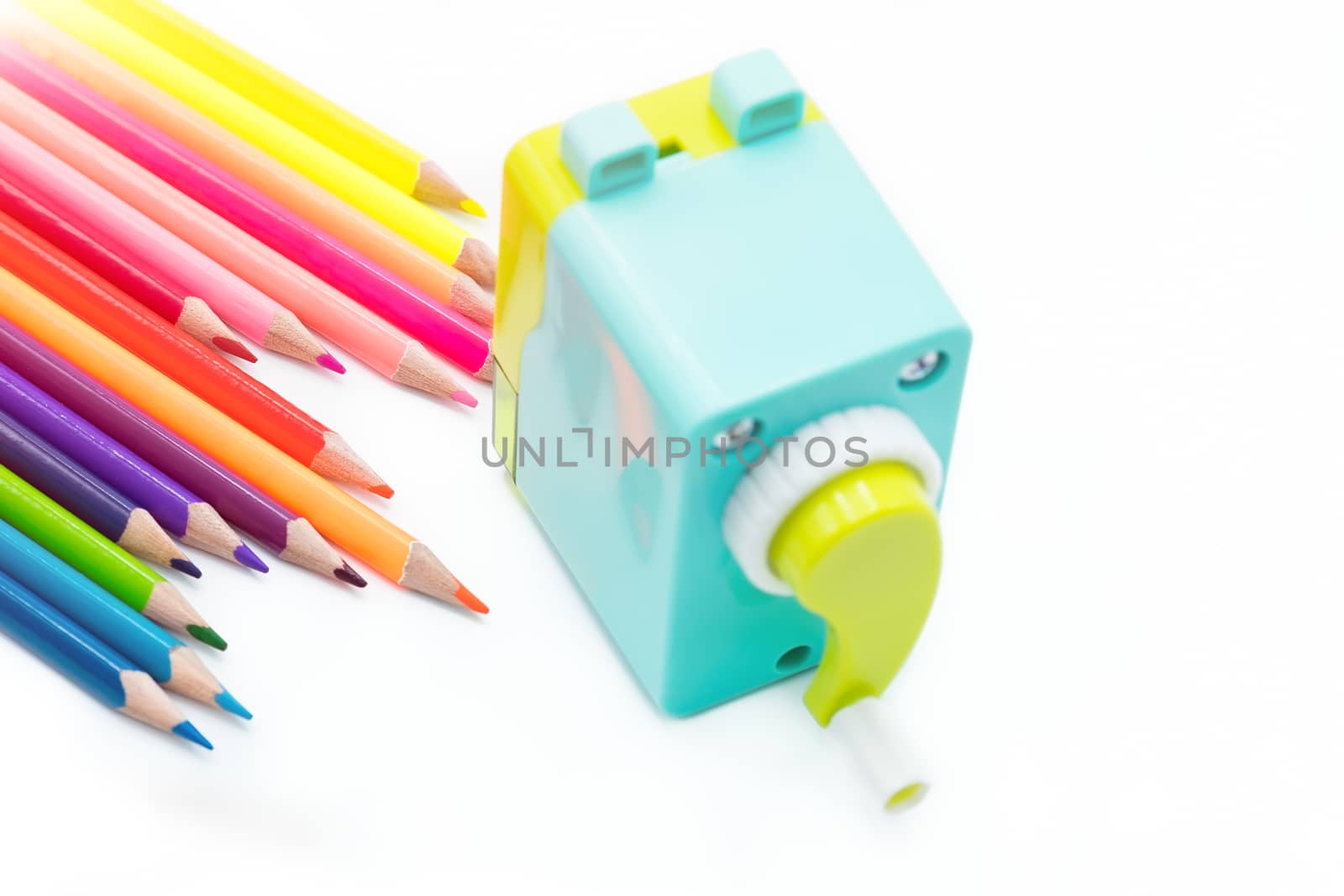 pastel blue yellow rotary pencil sharpener shavings with wooden colorful pencils isolated on white background, back to school education concept
