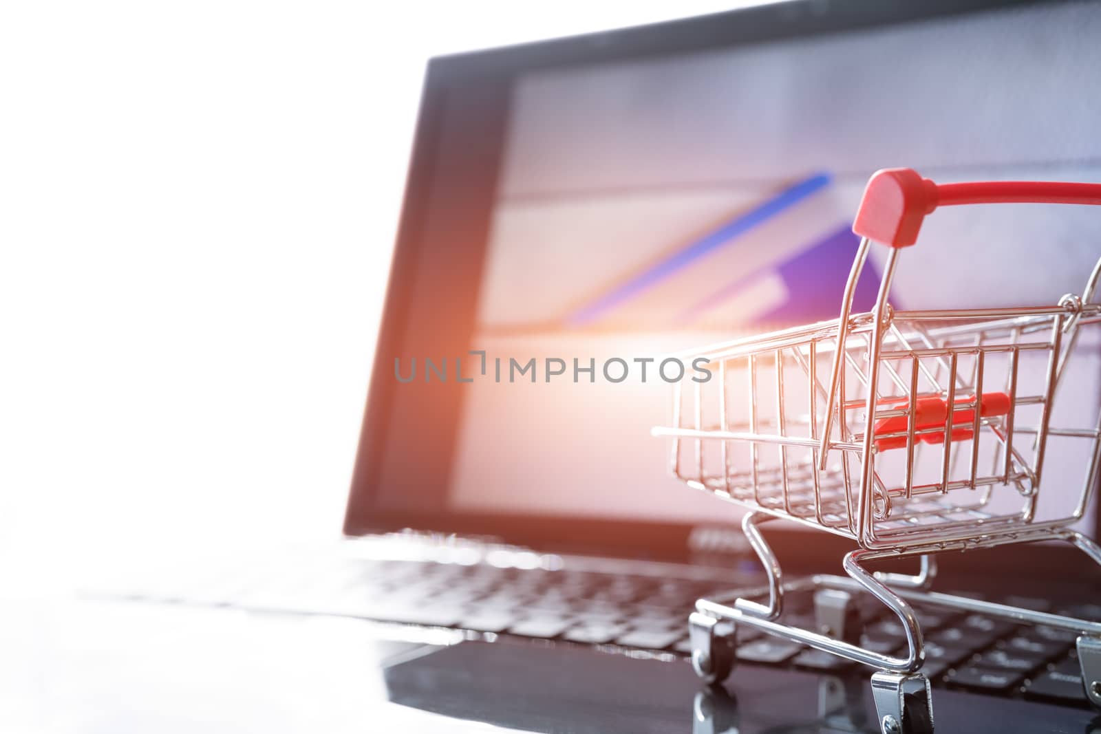 online shopping concept. Shopping cart trolley on the laptop with a credit card on the zipper bag